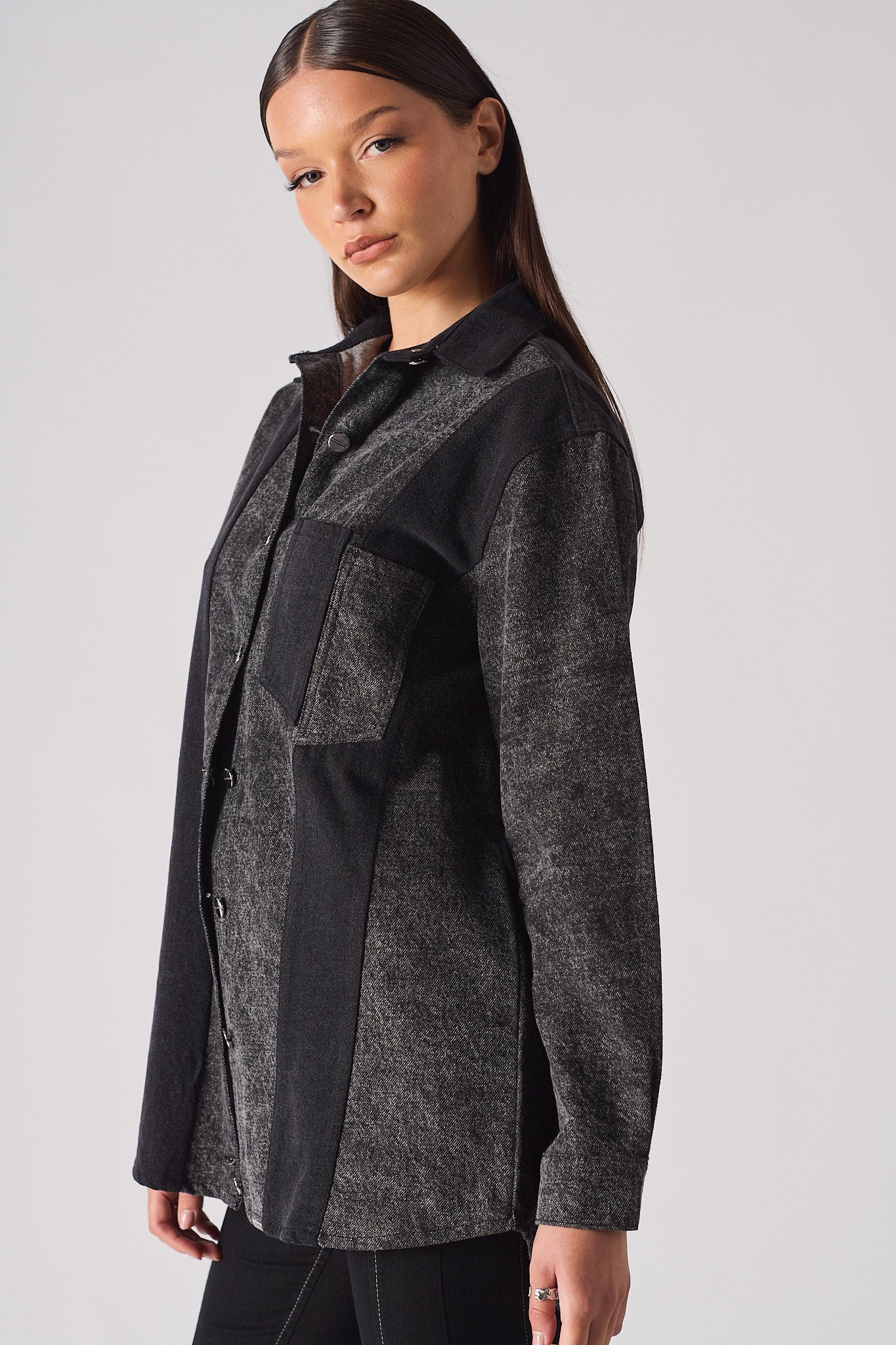 Angled side view of the women's acid wash jean shirt.