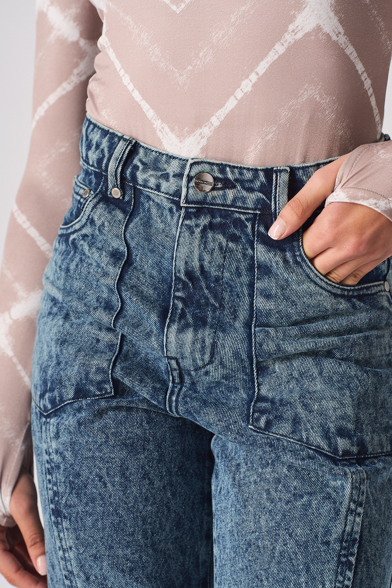 Close-up of the waist and pocket detail on the acid wash mom jeans.