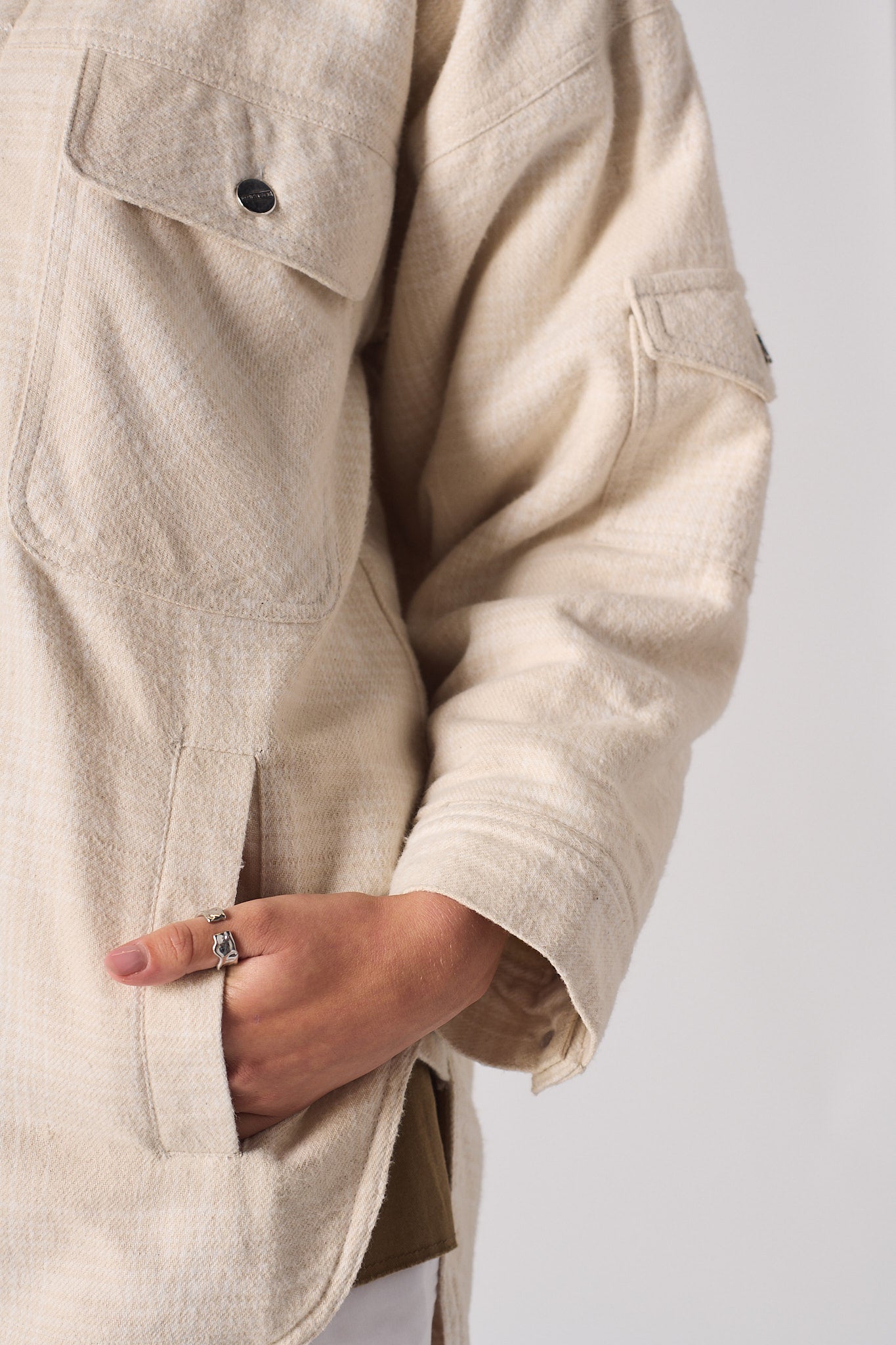 Close-up of the side pocket detail on the women's beige overshirt.