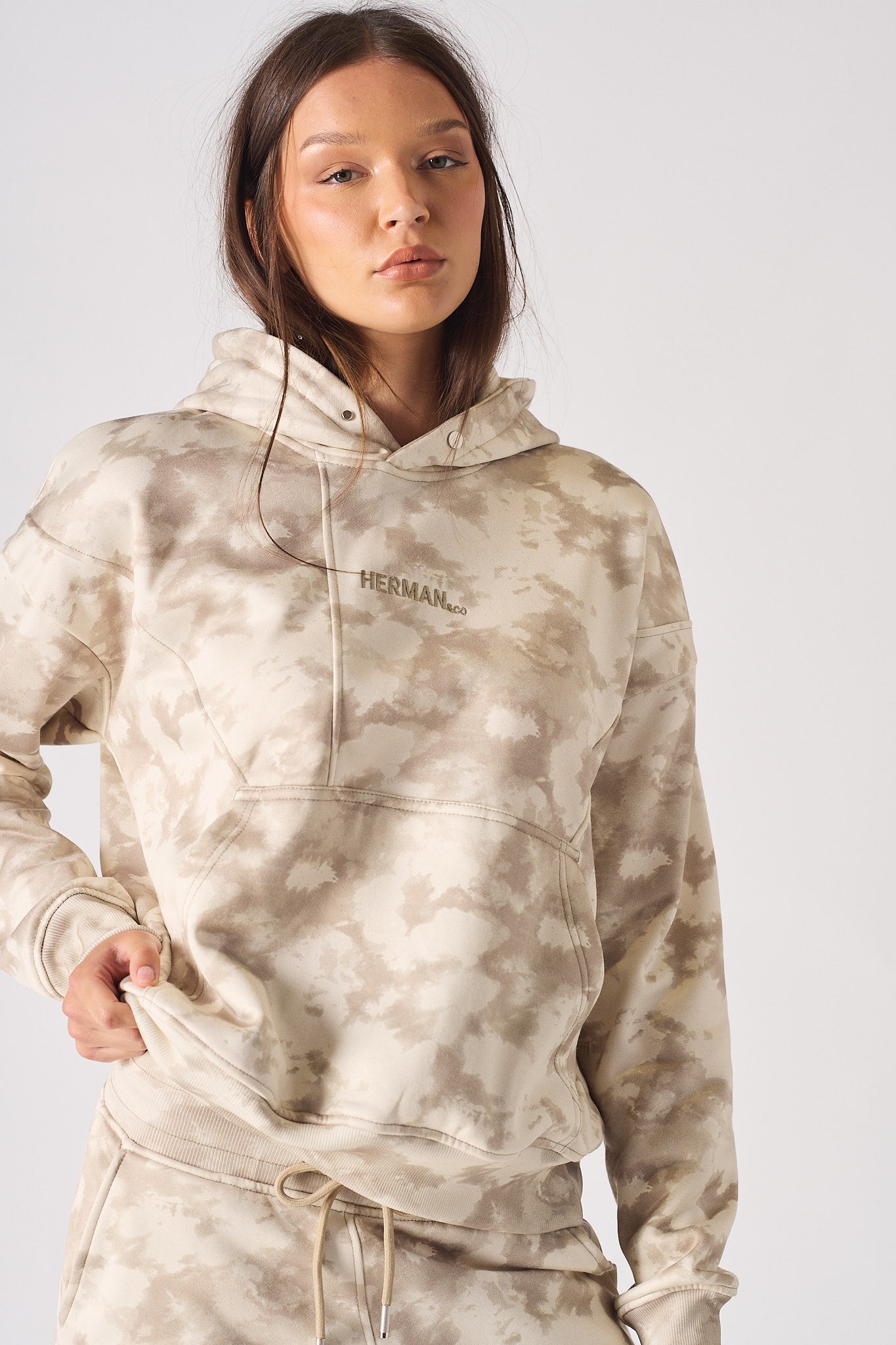 Close up side view of the front pocket on womens beige tie dye hoodie