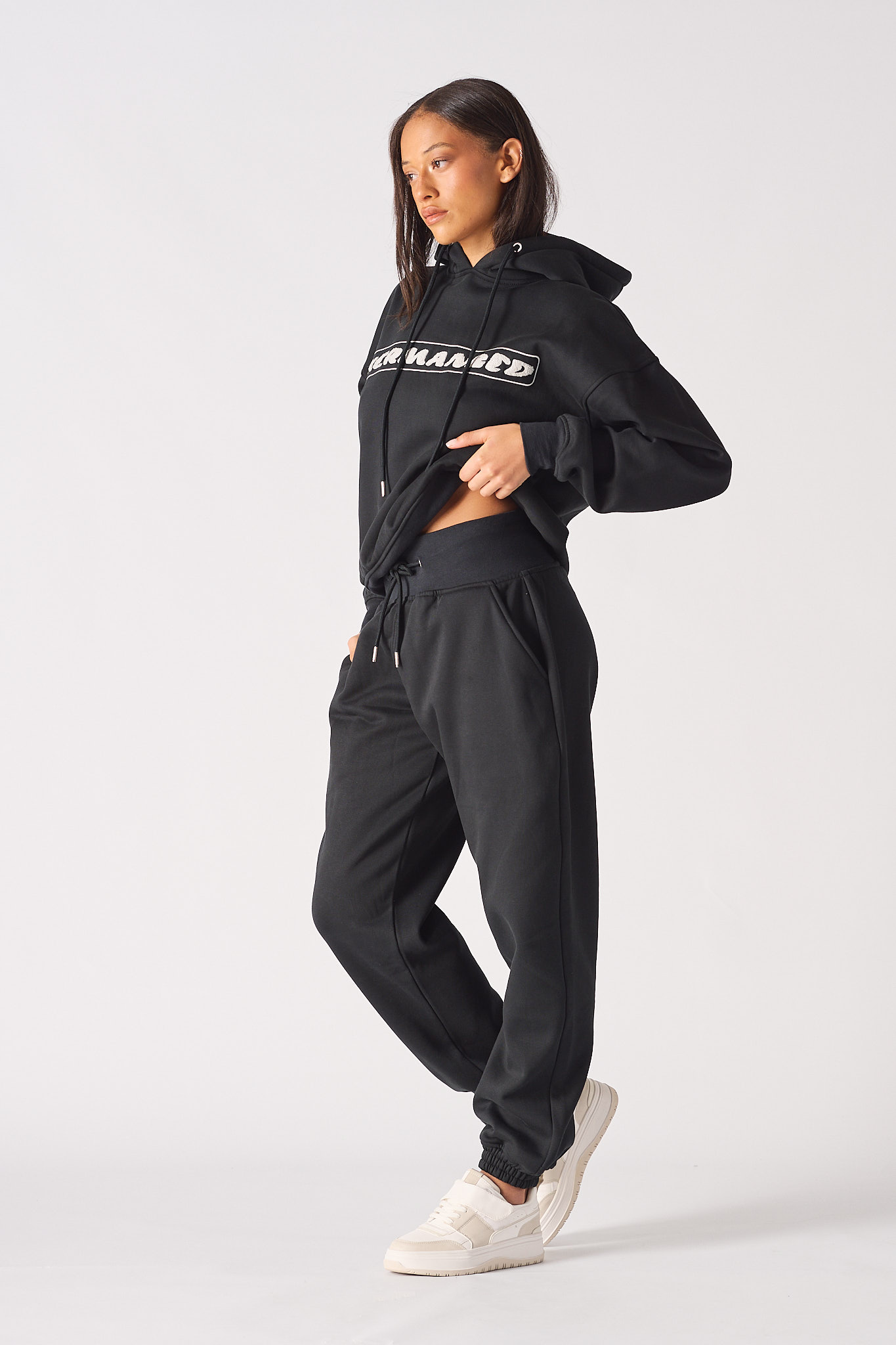 Detailed view of the logo print on the leg of black oversized joggers