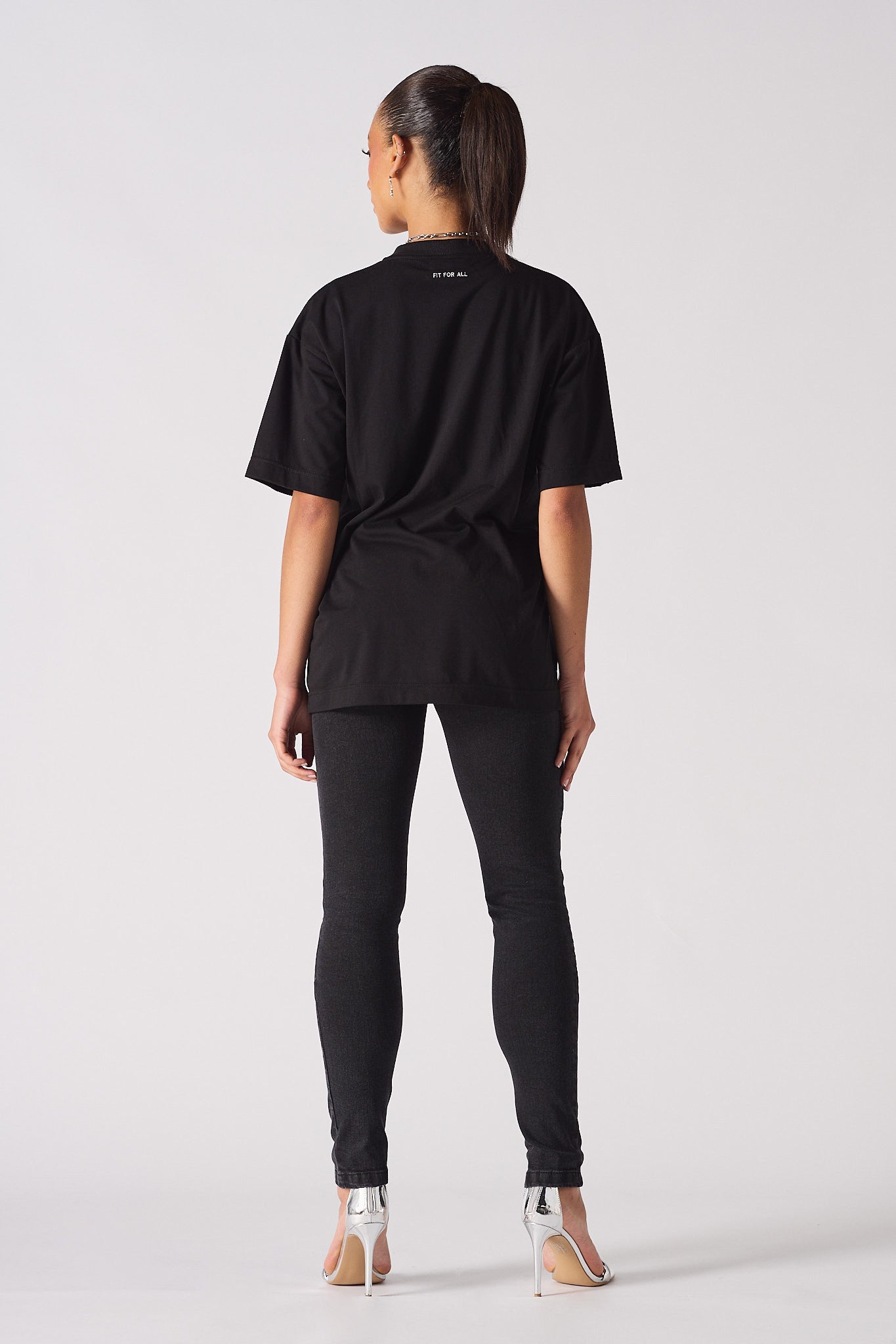 Back view of a model wearing the women's black skinny biker jeans.