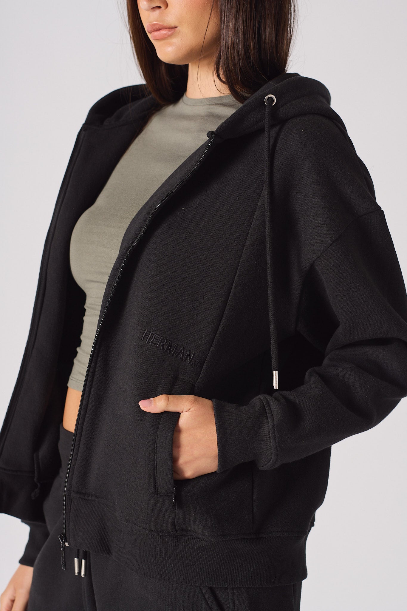 Close up detail of the side pocket on womens black zip up hoodie