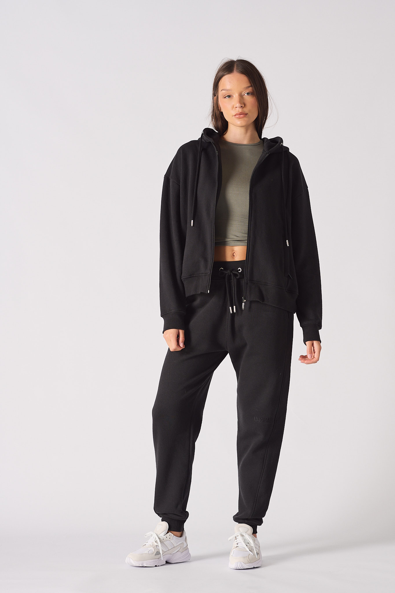 Full length view of model wearing black zip up hoodie womens with matching joggers