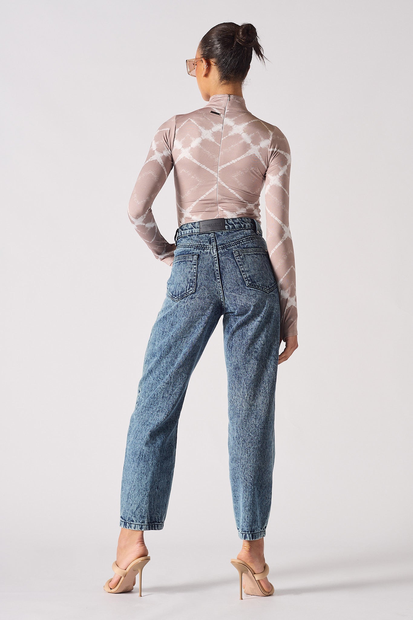 Back view of a model in the blue tapered acid wash mom jeans.