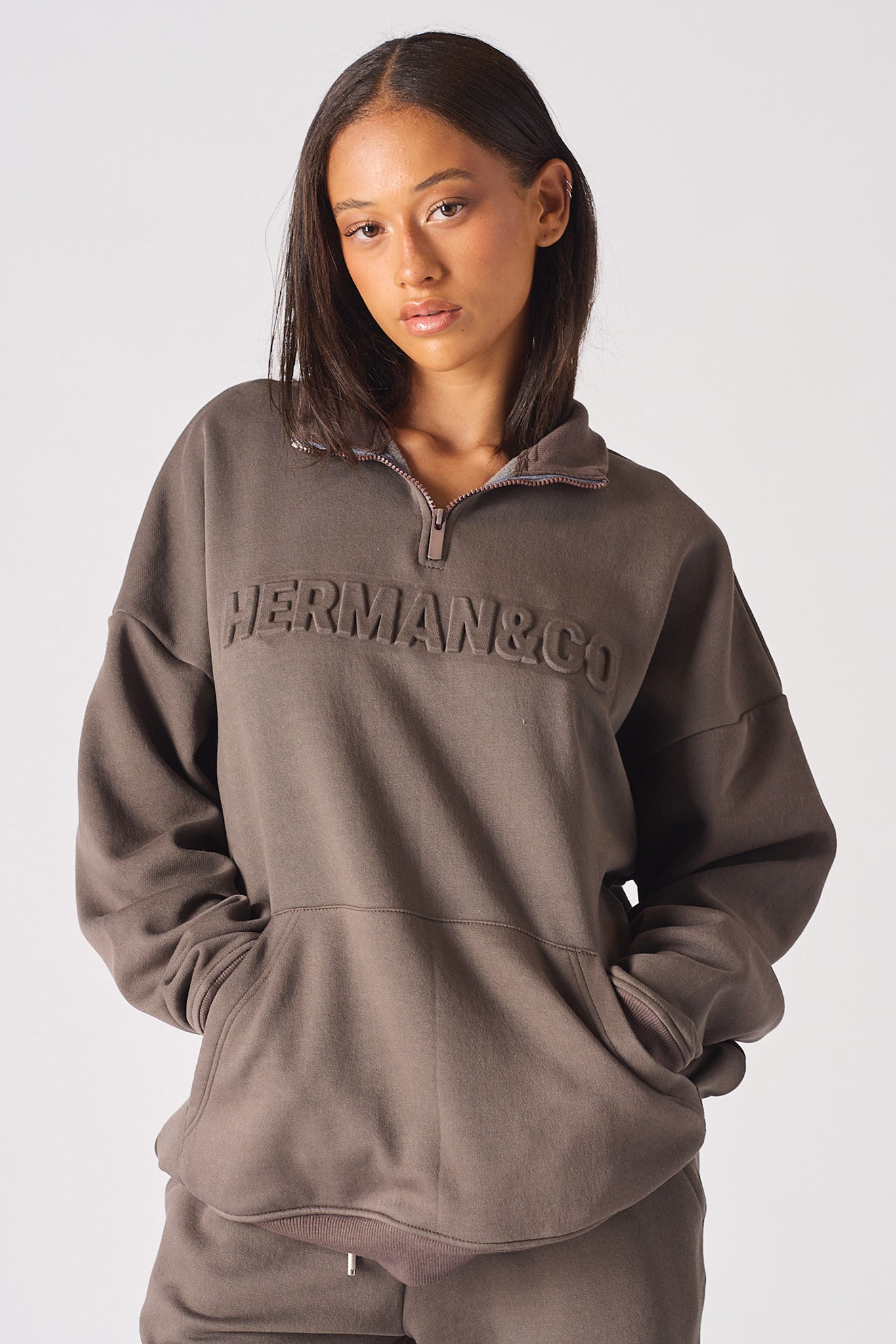Close up view of the front pocket detail on womens brown half zip sweatshirt