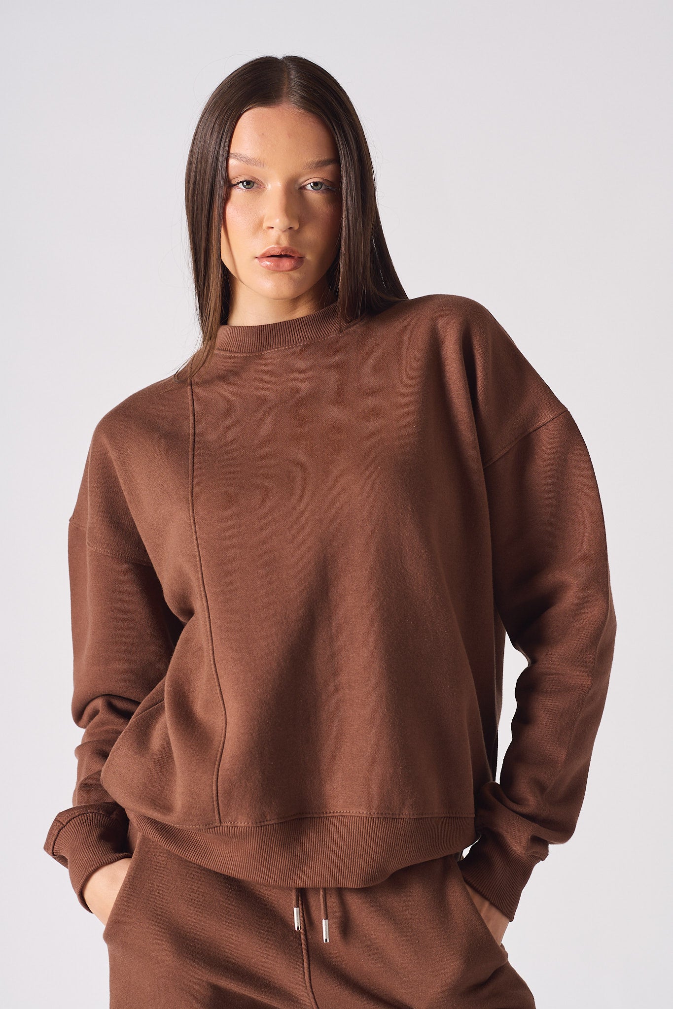 Close up detail of the ribbed crew neckline on womens brown jumper
