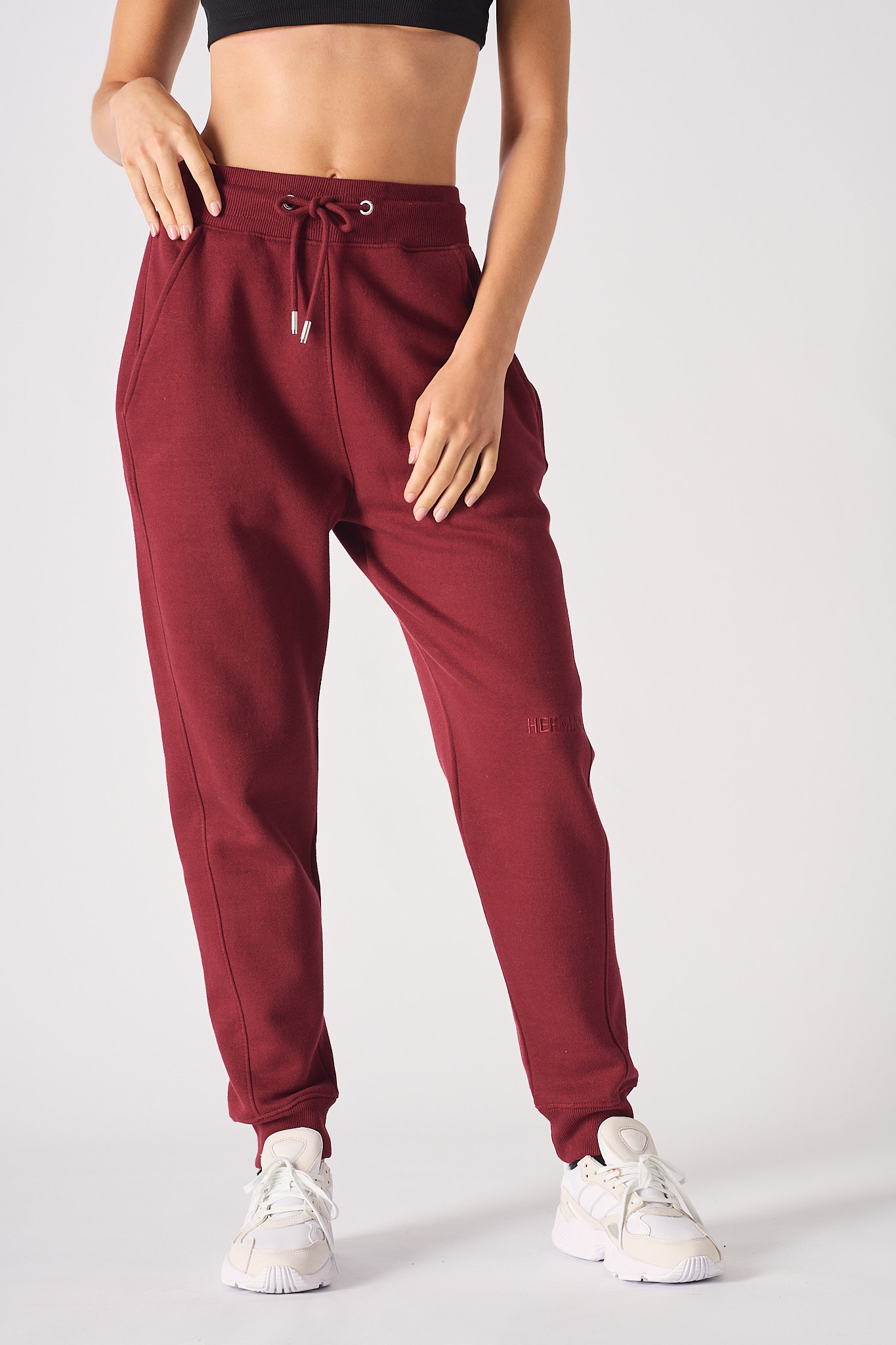 Close up detail of the elasticated waist and drawstring on burgundy joggers