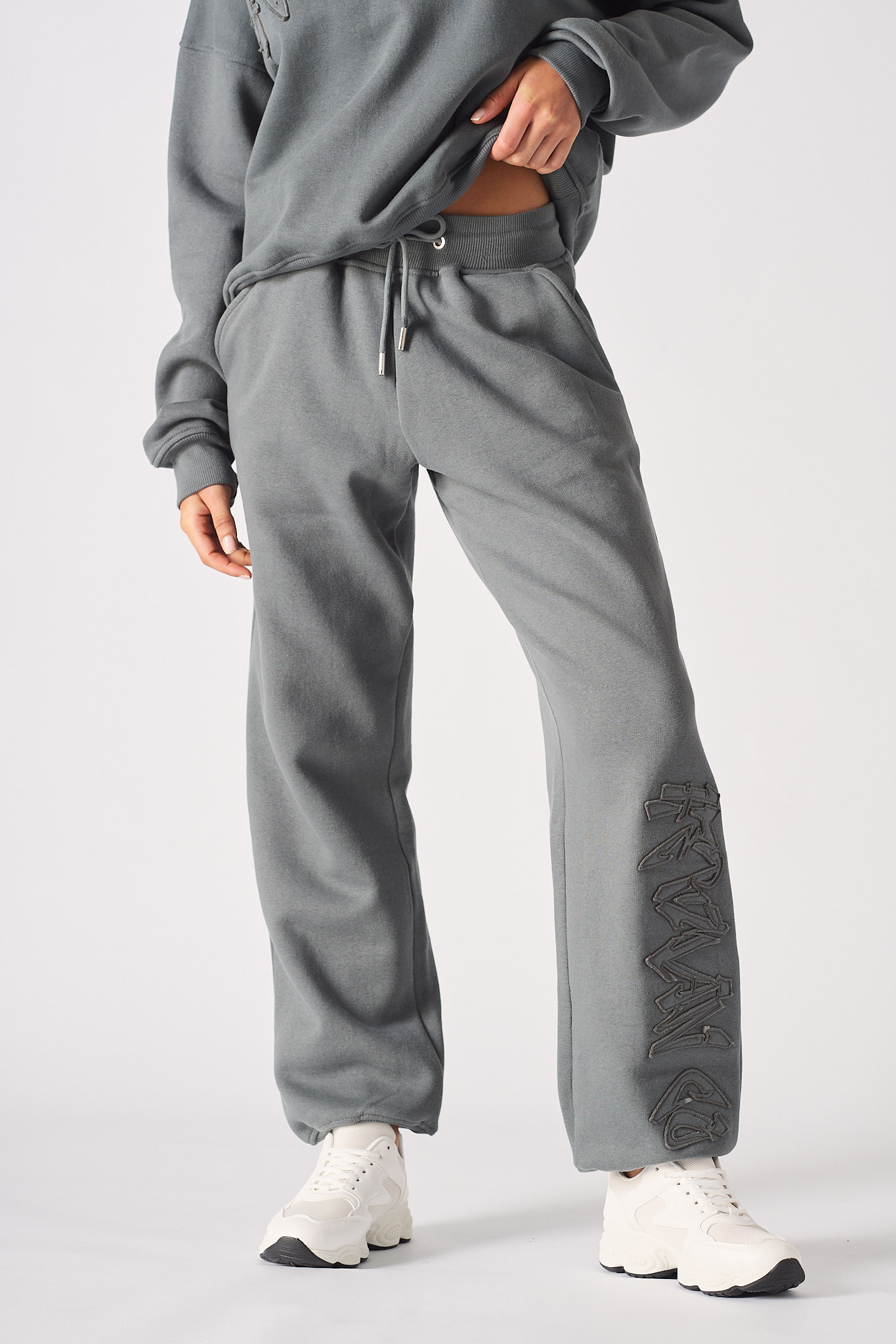 Full front view of a model wearing the cuffed leg joggers in grey.