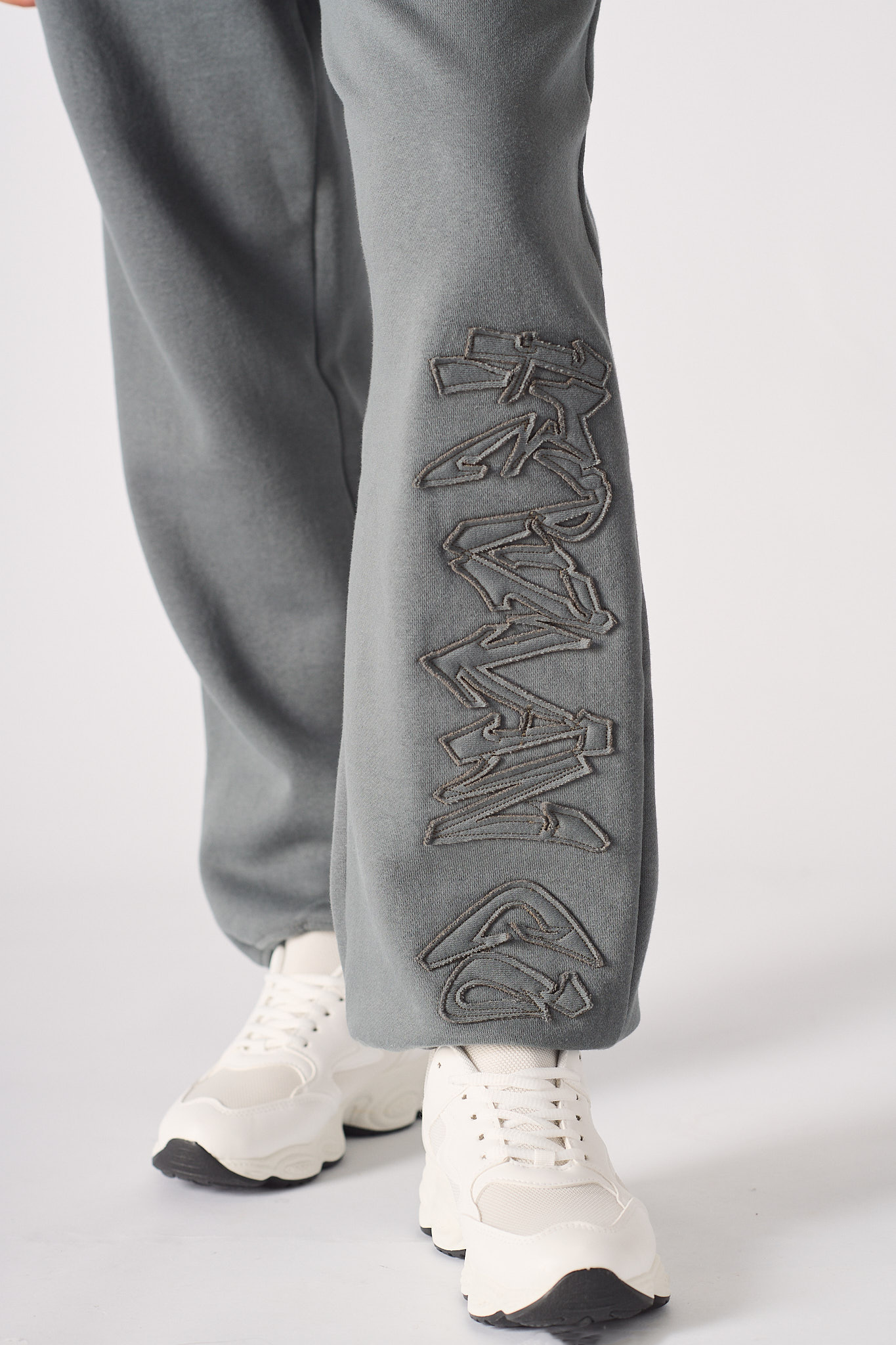 Close-up of the embroidered detail on the leg of the cuffed joggers.