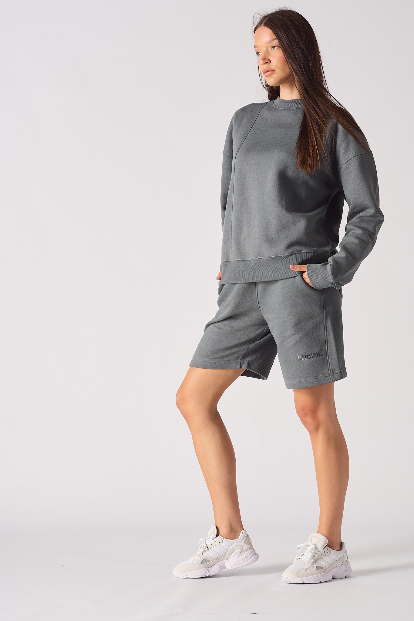 Side profile of model showing the drop shoulder fit of grey jumper