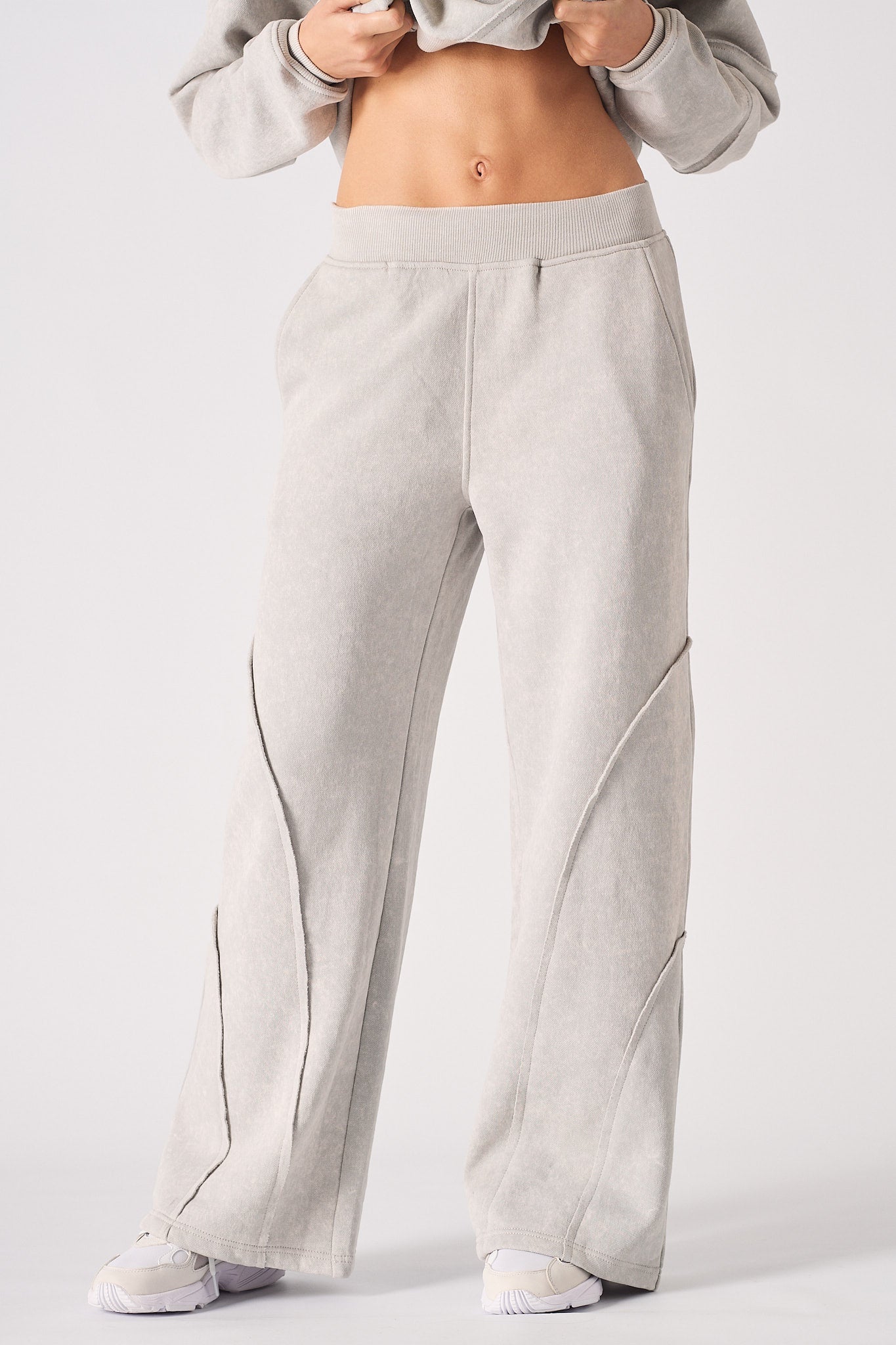 Close-up of the grey wide-leg joggers showing the front seam detail.