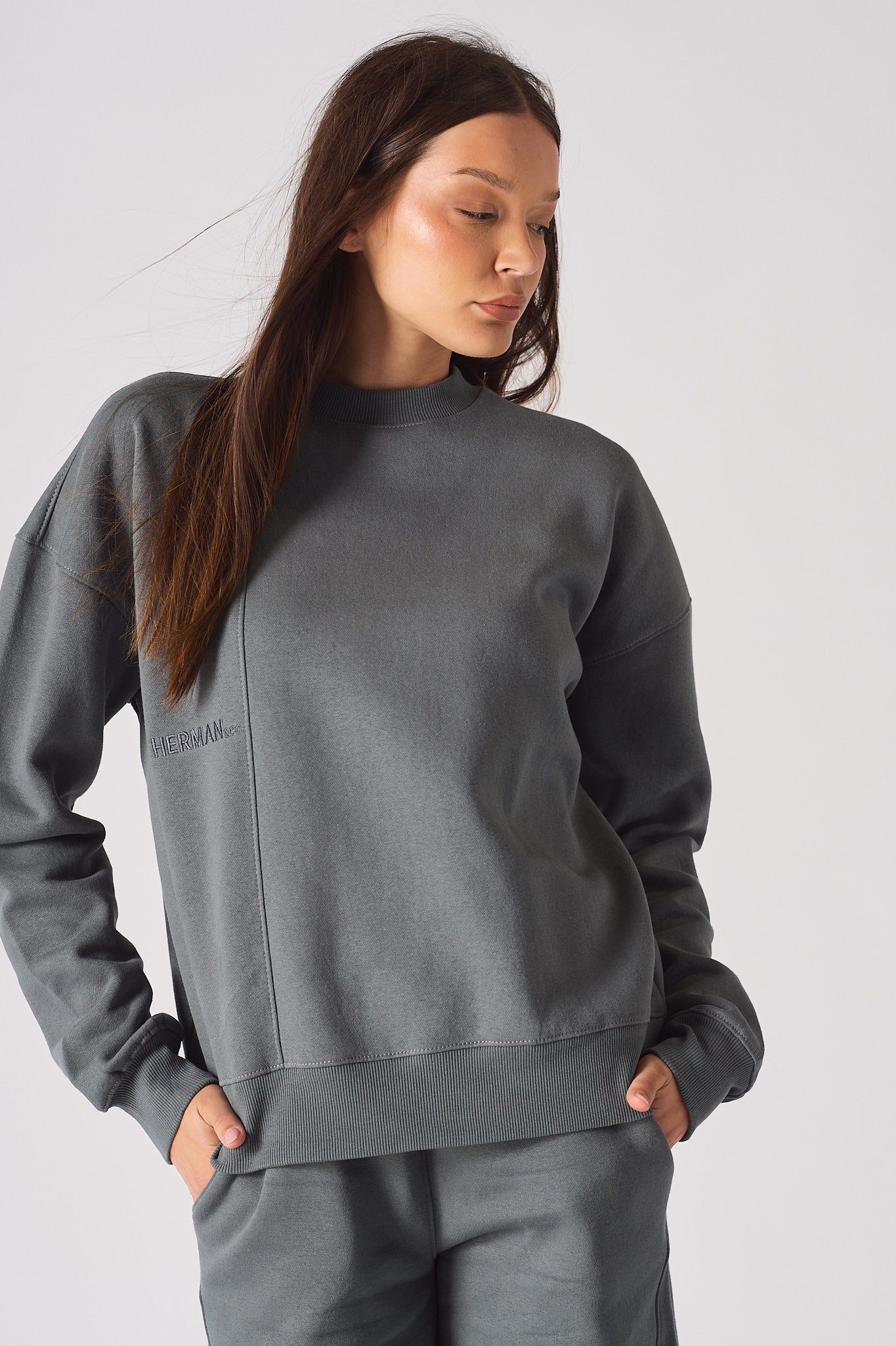 Close up detail of the HERMAN logo embroidery on the chest