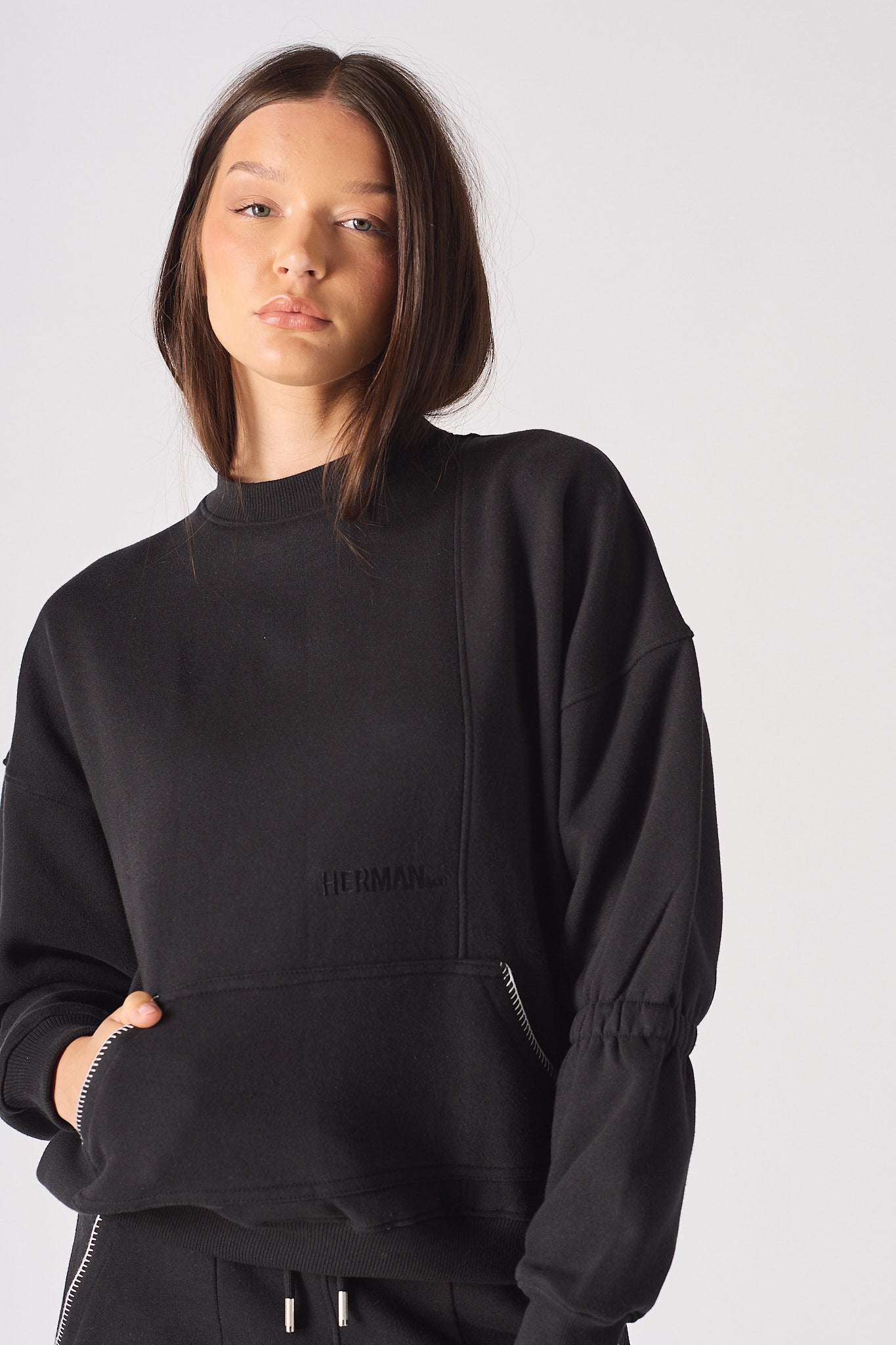 A model wearing the oversized black jumper with blanket stitch detailing.