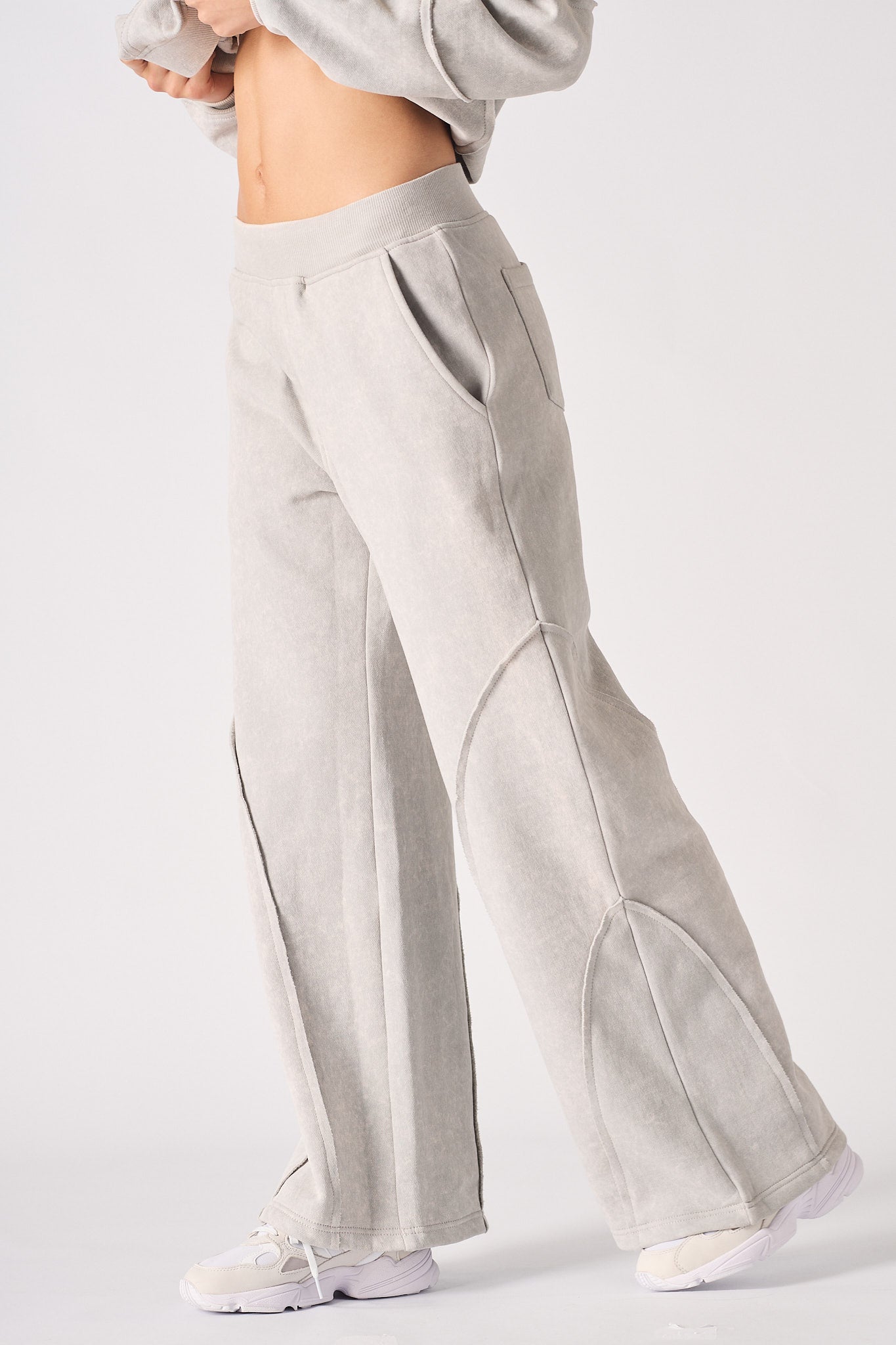 Side view of the oversized grey joggers highlighting the seam detailing.