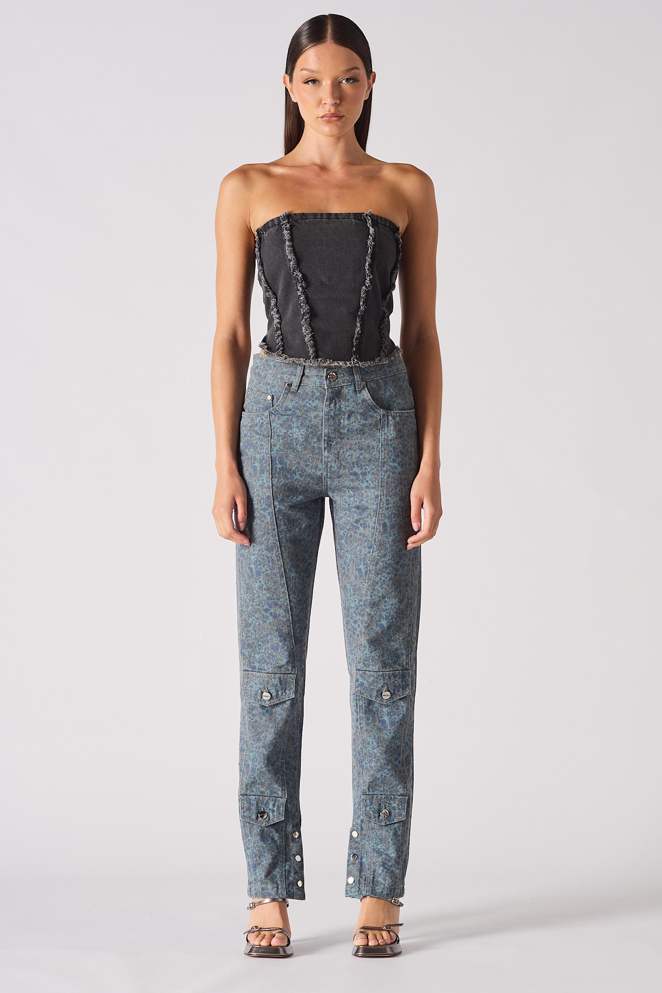 A model styled in the black textured corset with printed trousers.