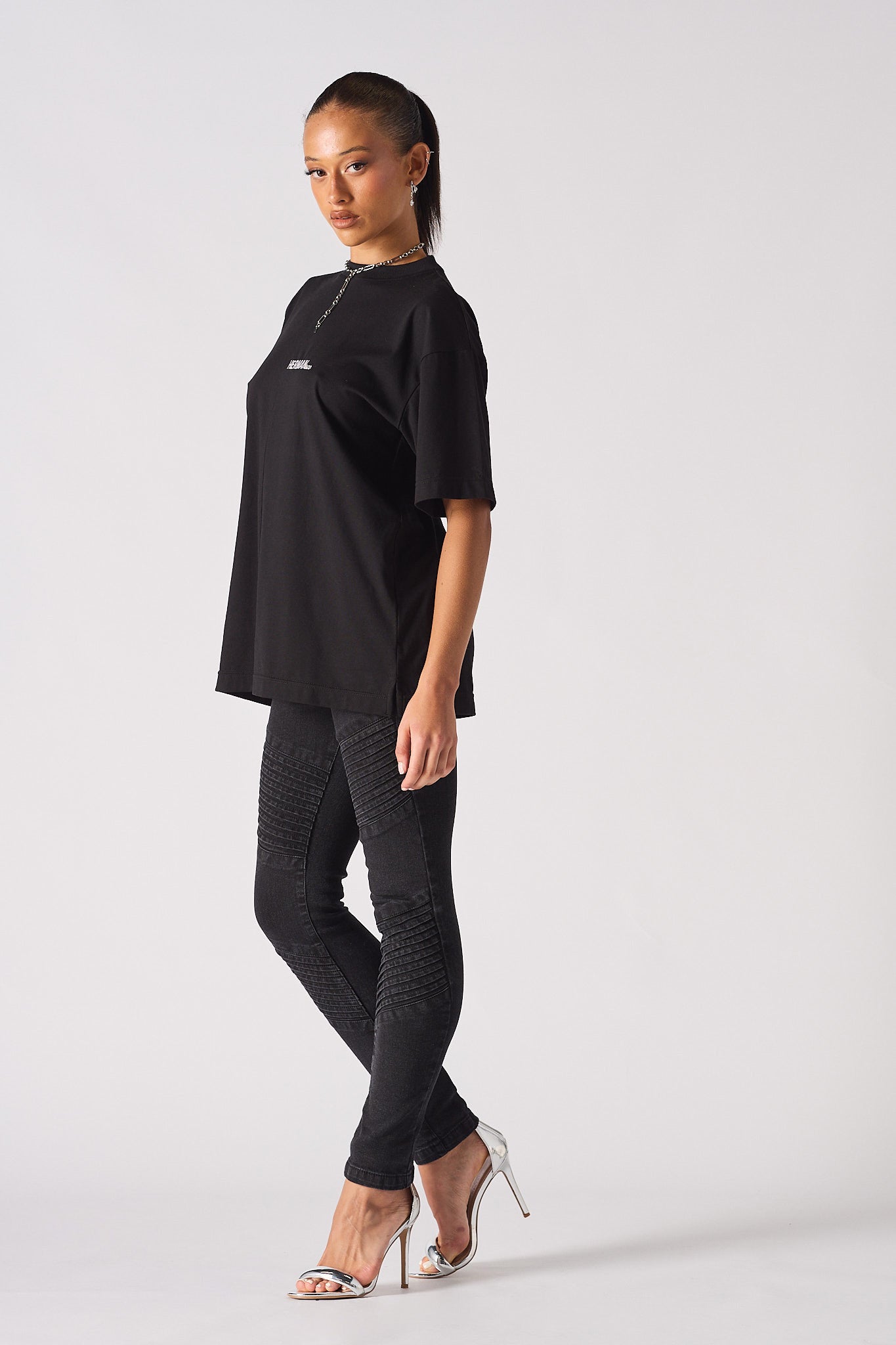 A model showing how to style the black skinny biker jeans for women.