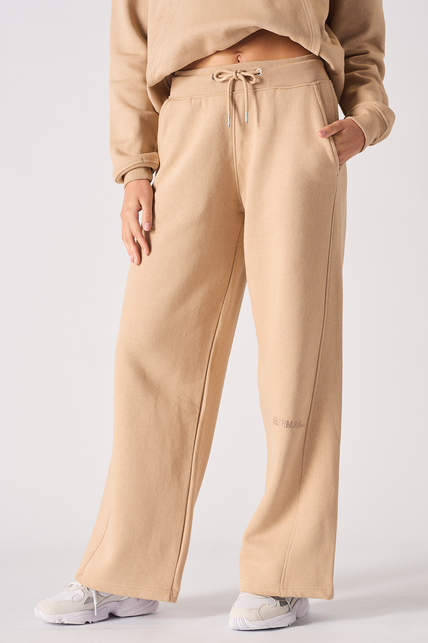 A model styled in the women's beige wide-leg joggers.