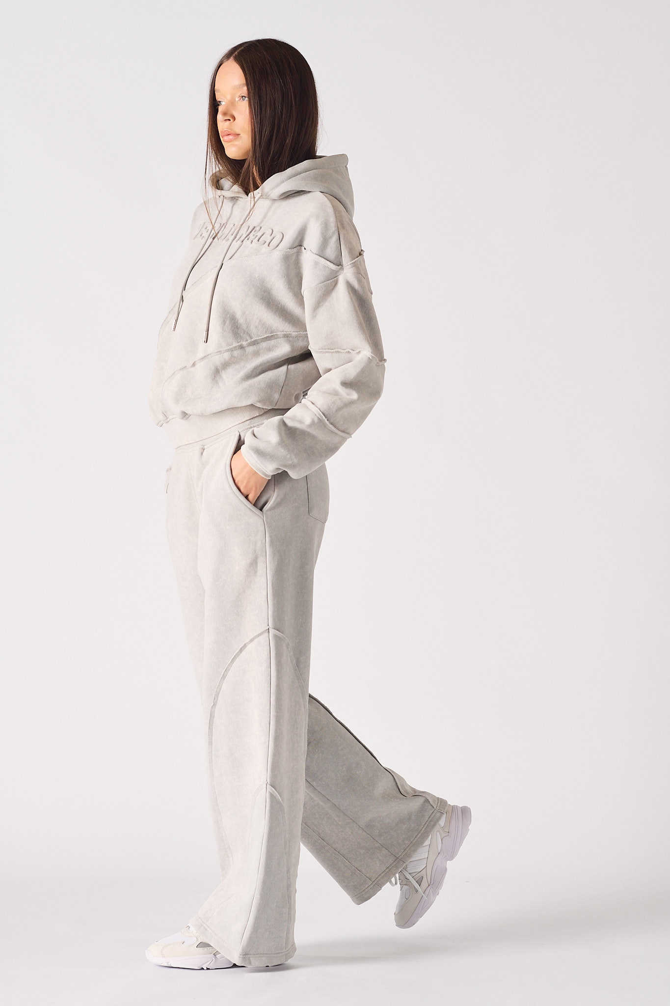 Side profile of a model walking in the wide-leg seam detail joggers.