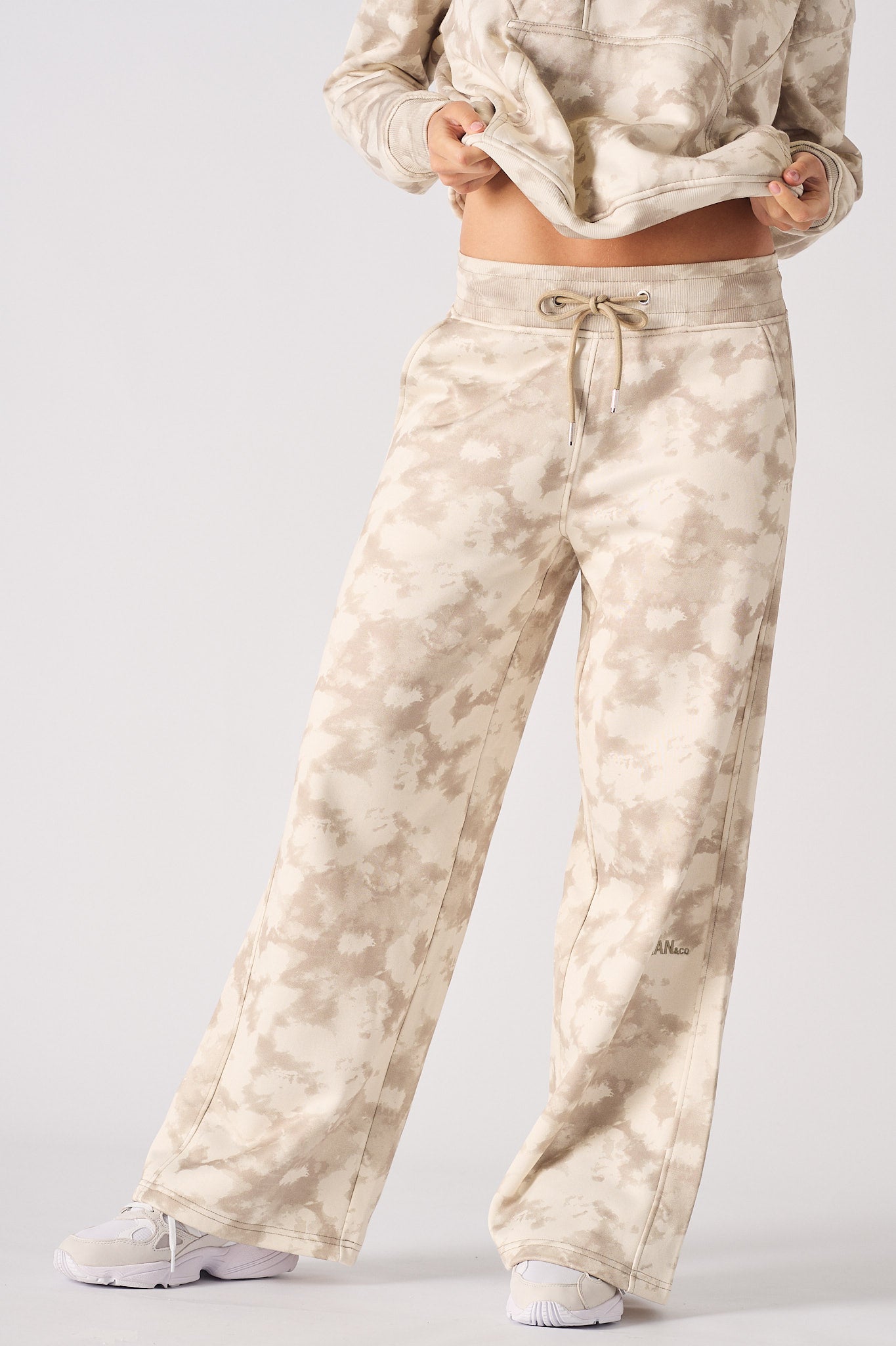 Side profile view showing the loose fit of women's beige tie dye joggers