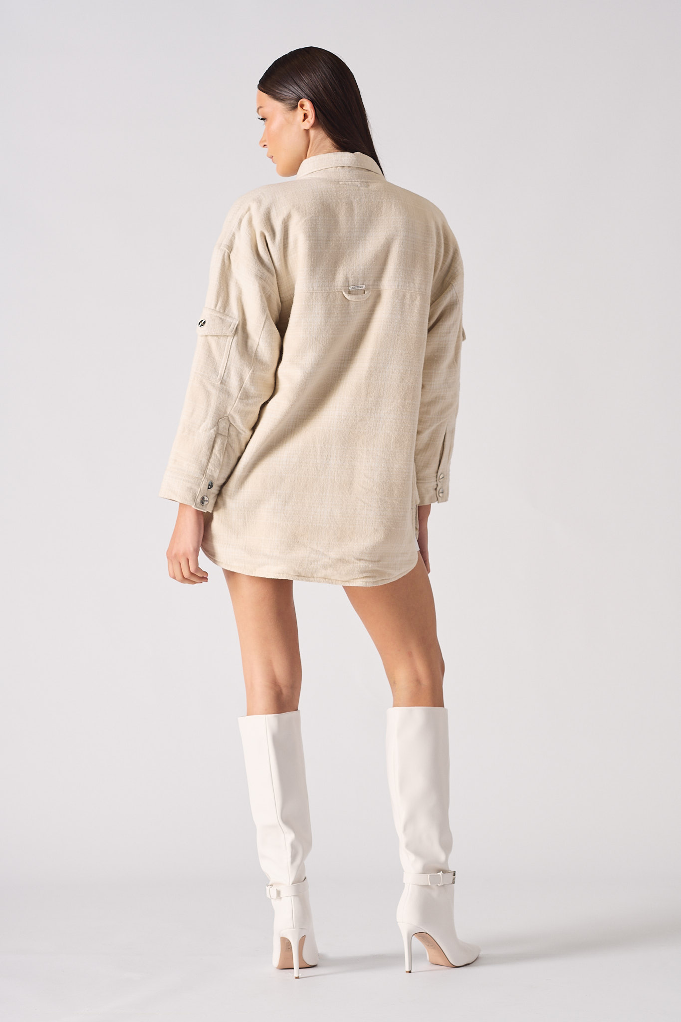 Back view of a model in the women's beige check overshirt.