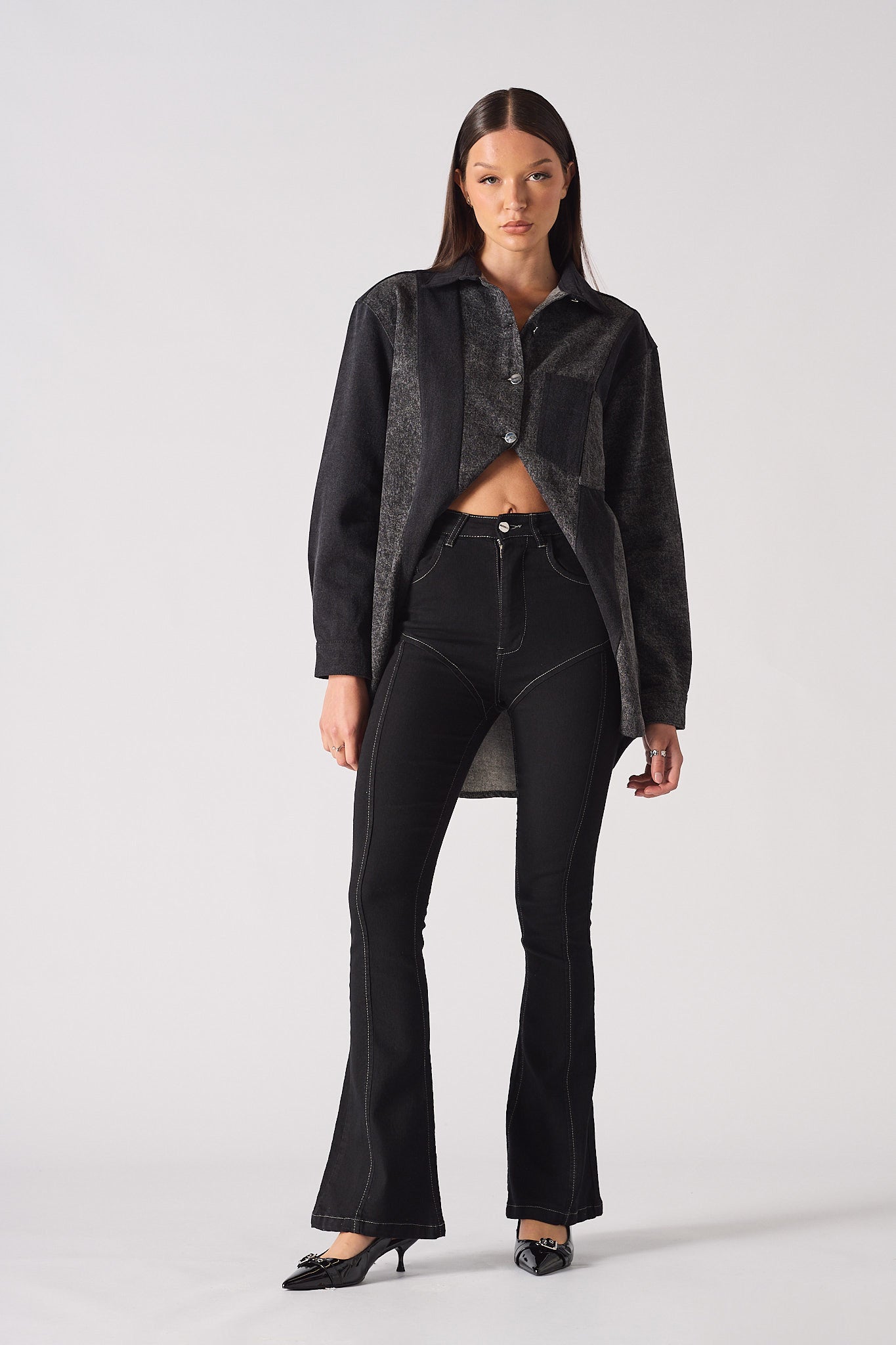 Full front view of a model styled in the women's black high-rise flare jeans.