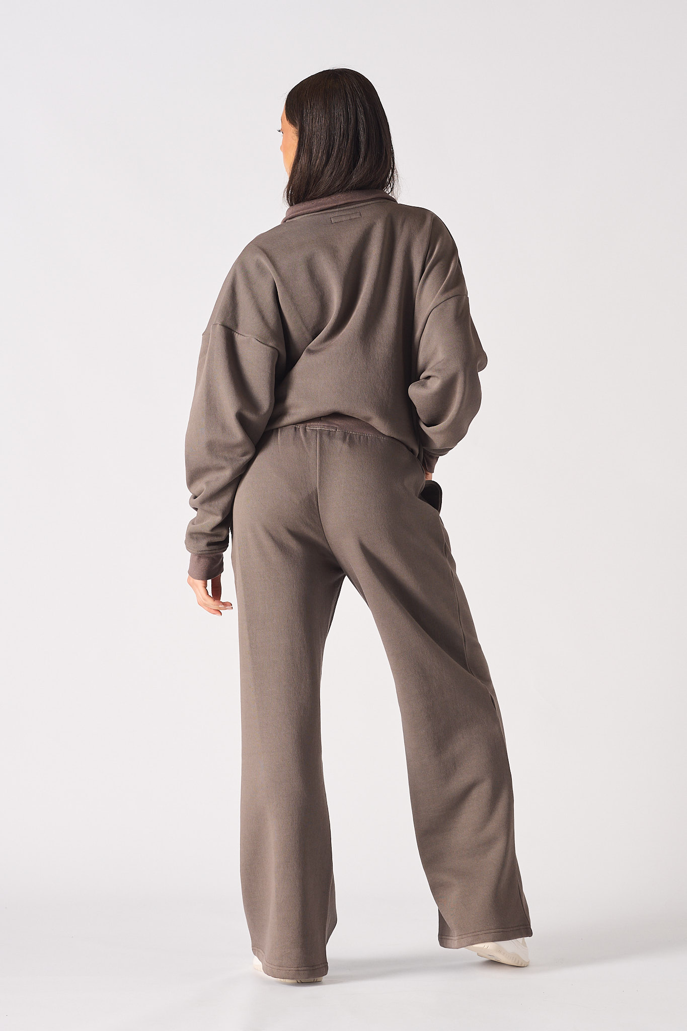 Back view of a model in the women's brown baggy joggers and hoodie set.