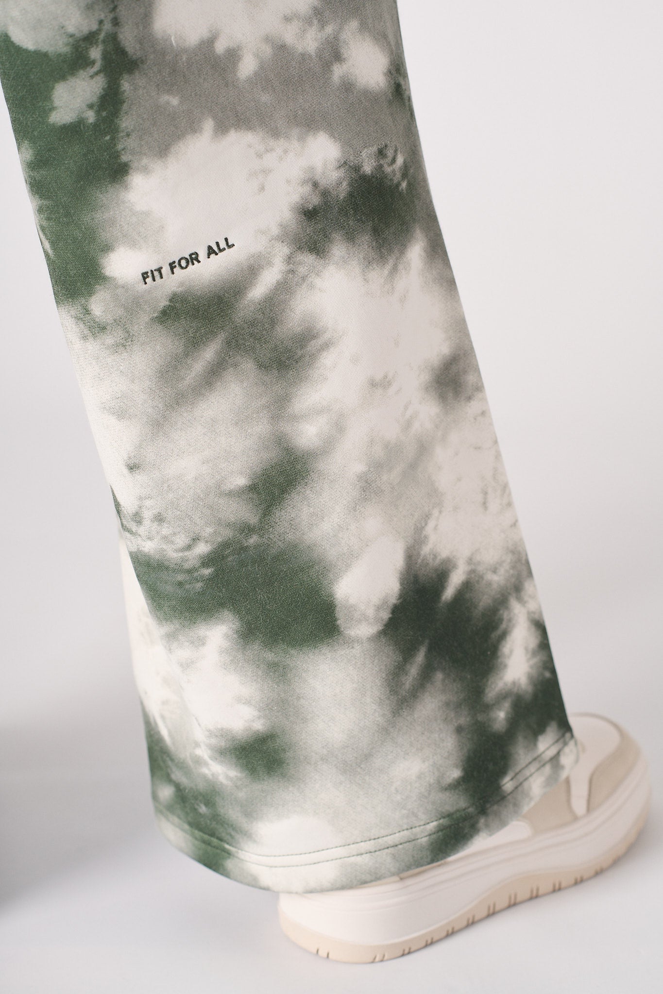 Detailed view of the tonal logo embroidery on the women's tie-dye joggers.
