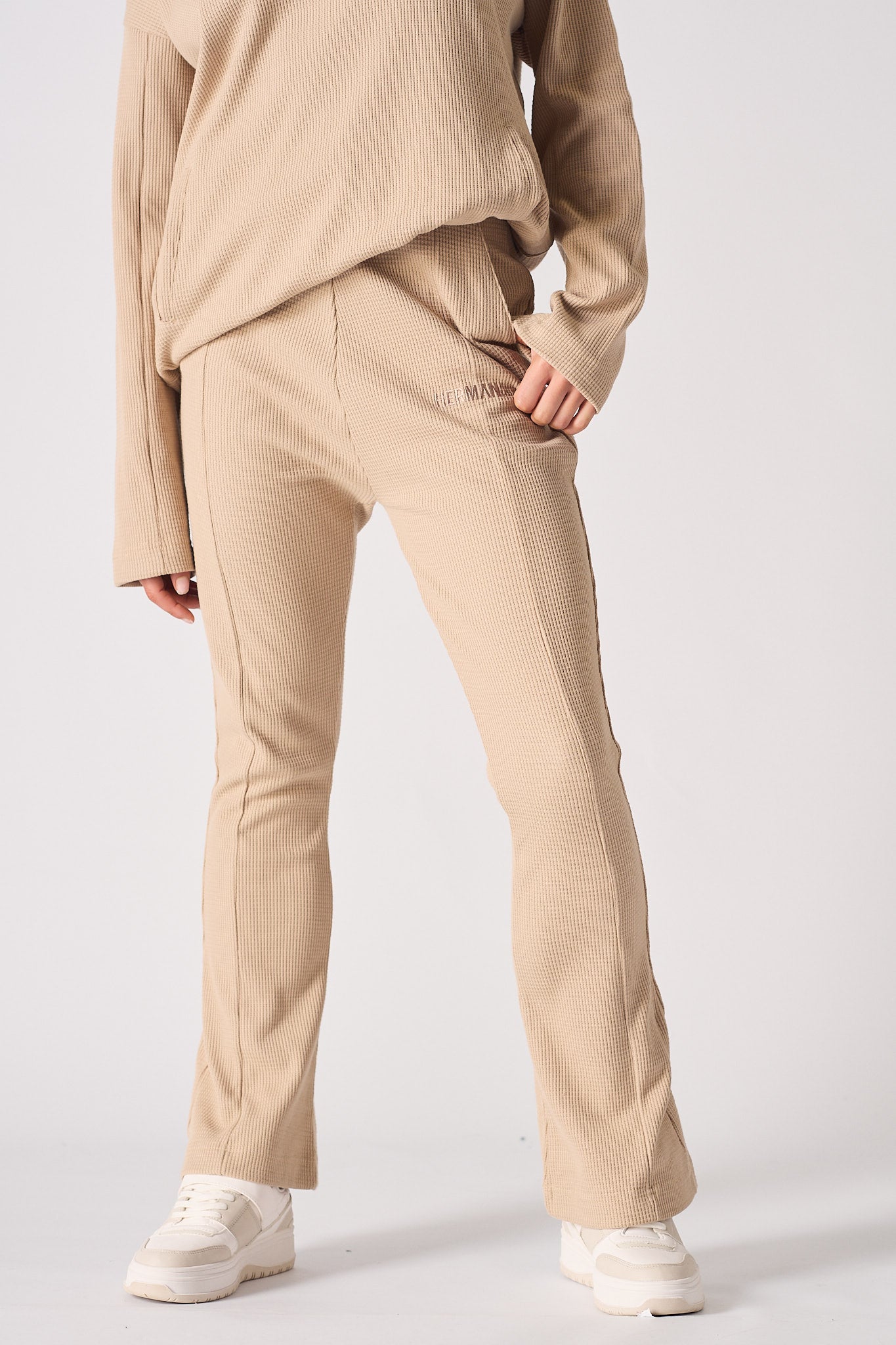 Detailed front view of the women's beige flare joggers with seam detailing