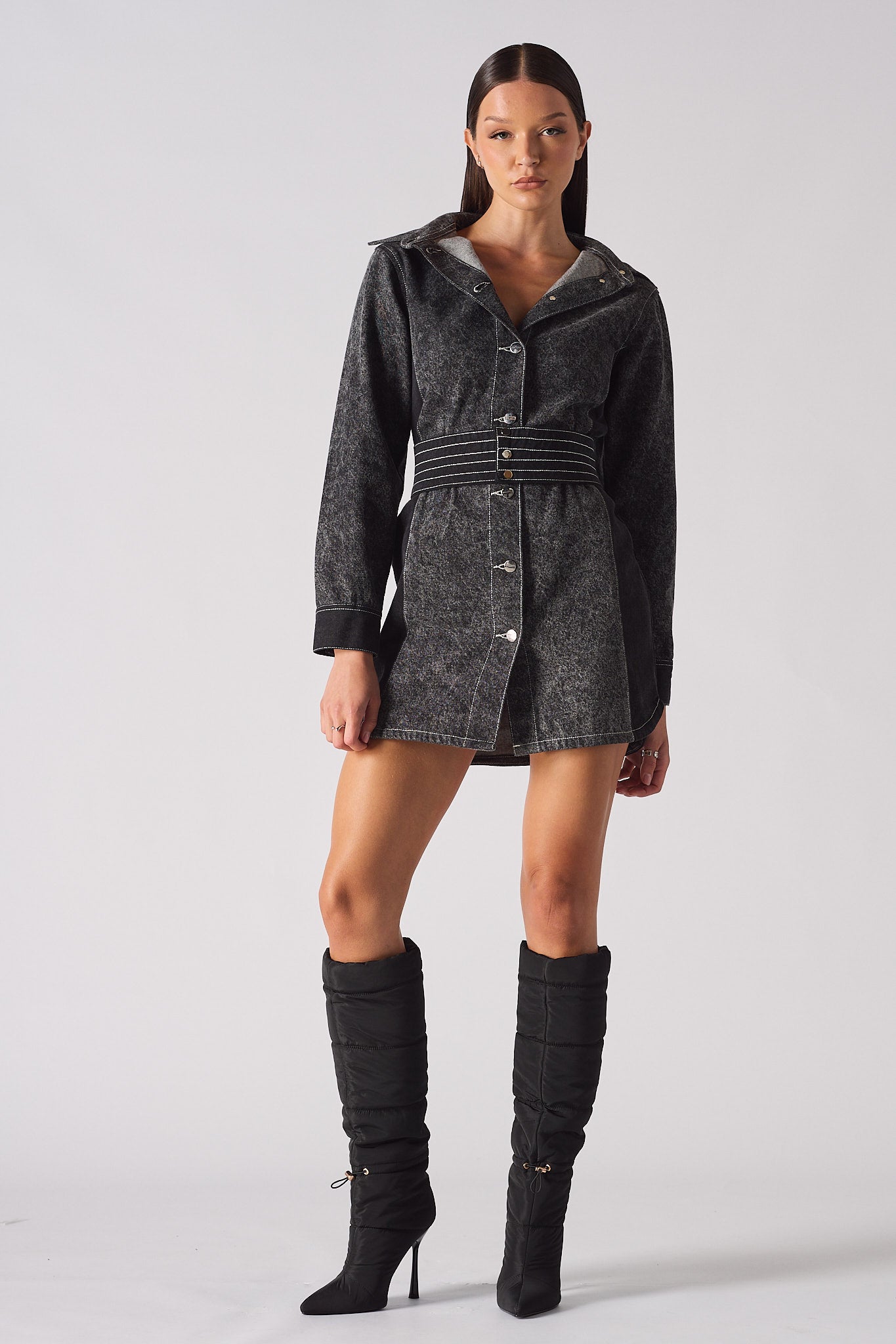 Model facing forward in the women's black acid wash denim dress, showing the full outfit