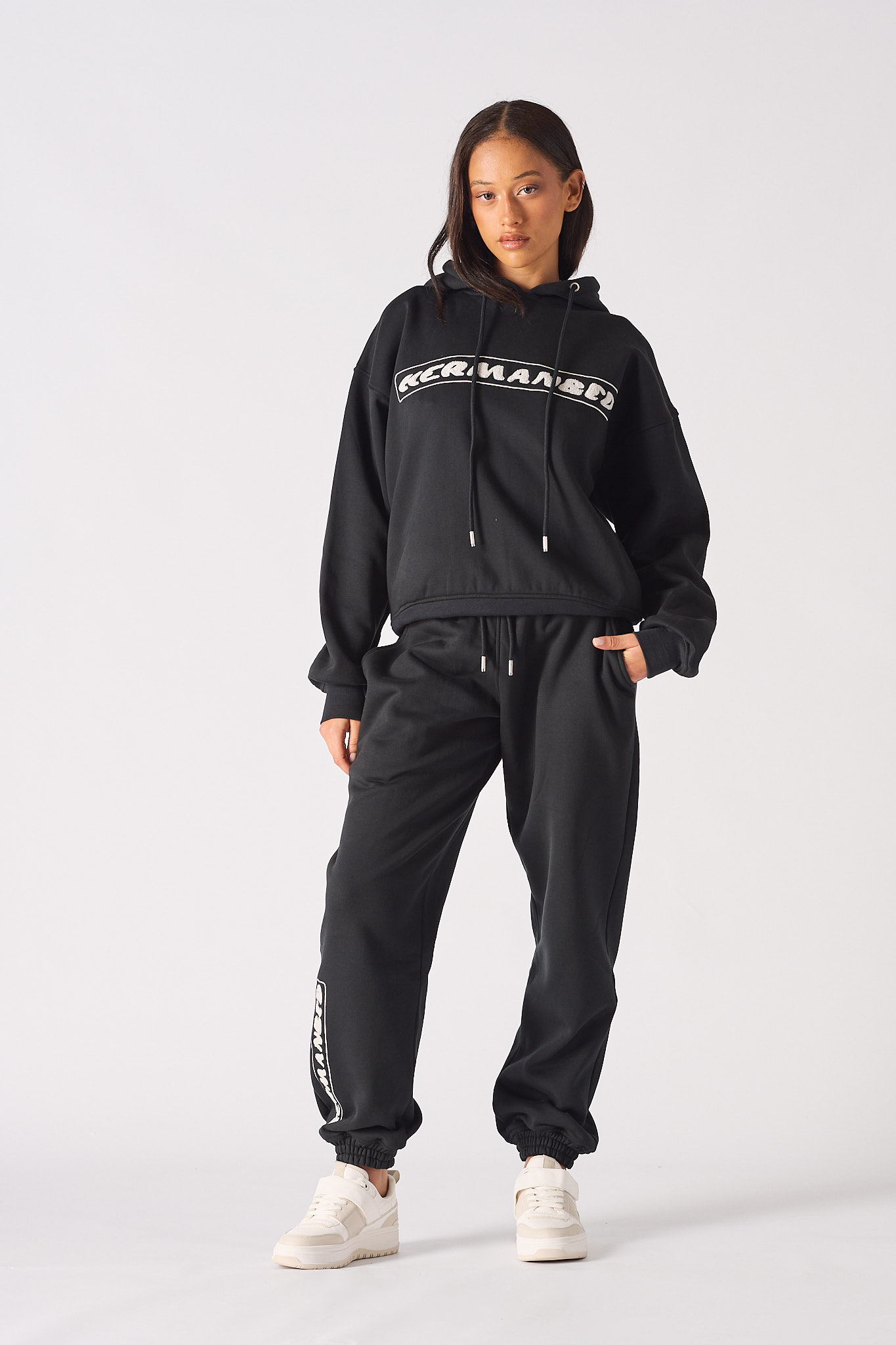 Model posing in a casual streetwear style wearing black oversized hoodie womens