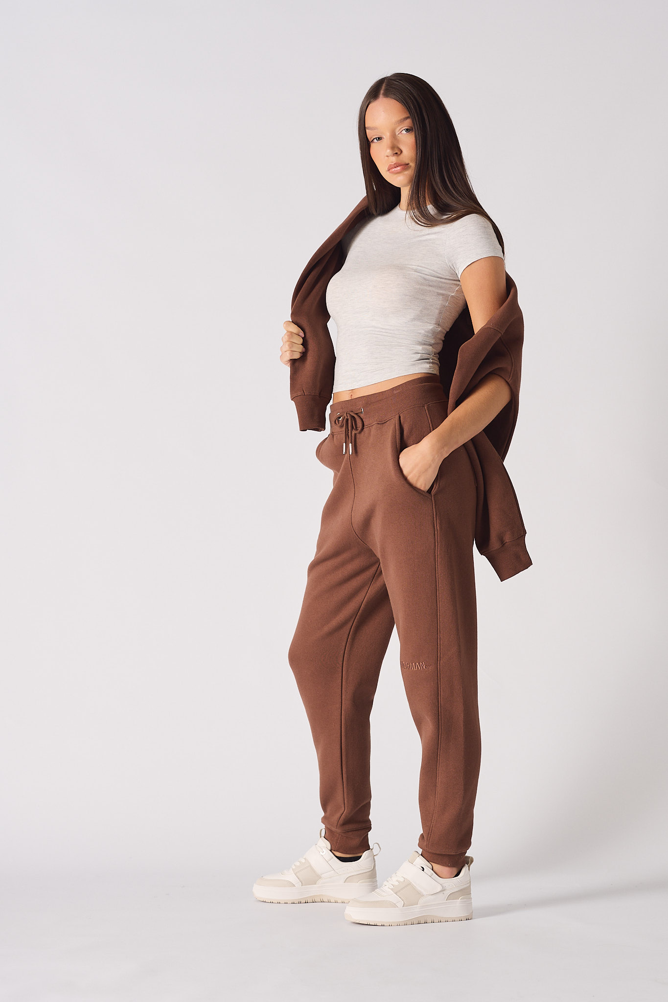 A model styled in the women's brown tapered jogger with a matching hoodie.