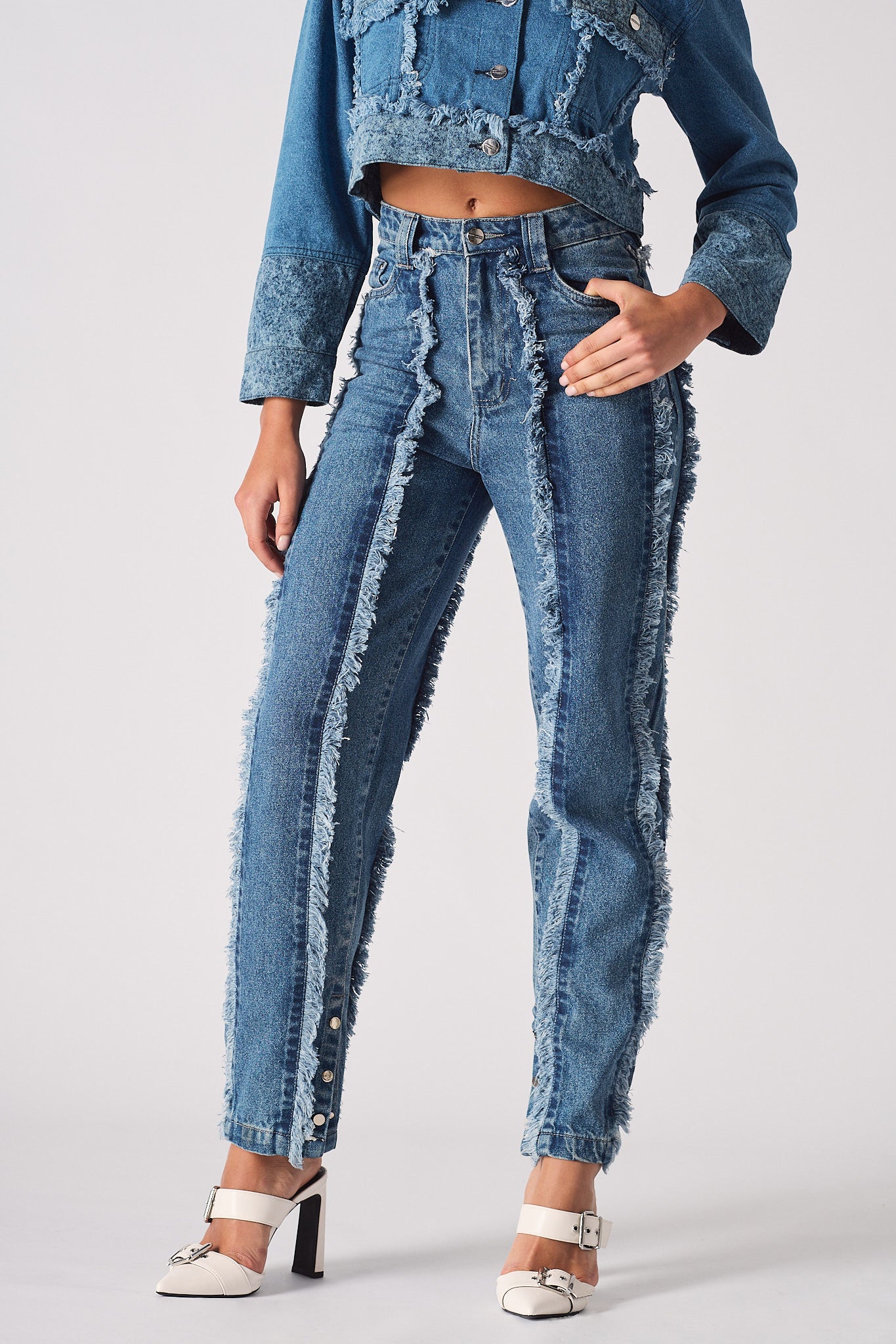 Front close-up of the women's distressed blue straight leg jeans with frayed seams.