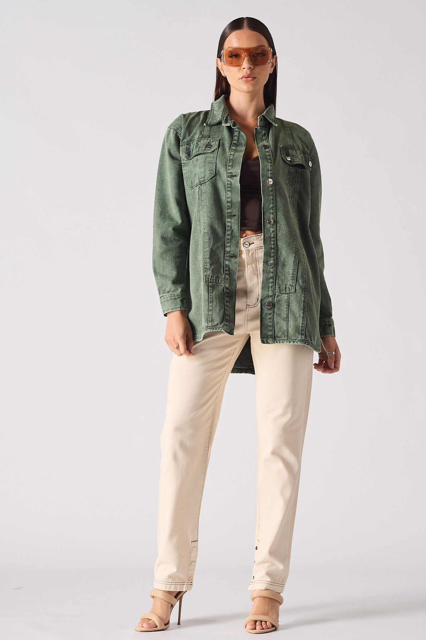 A model styled in the women's green denim shirt, worn as an overshirt.