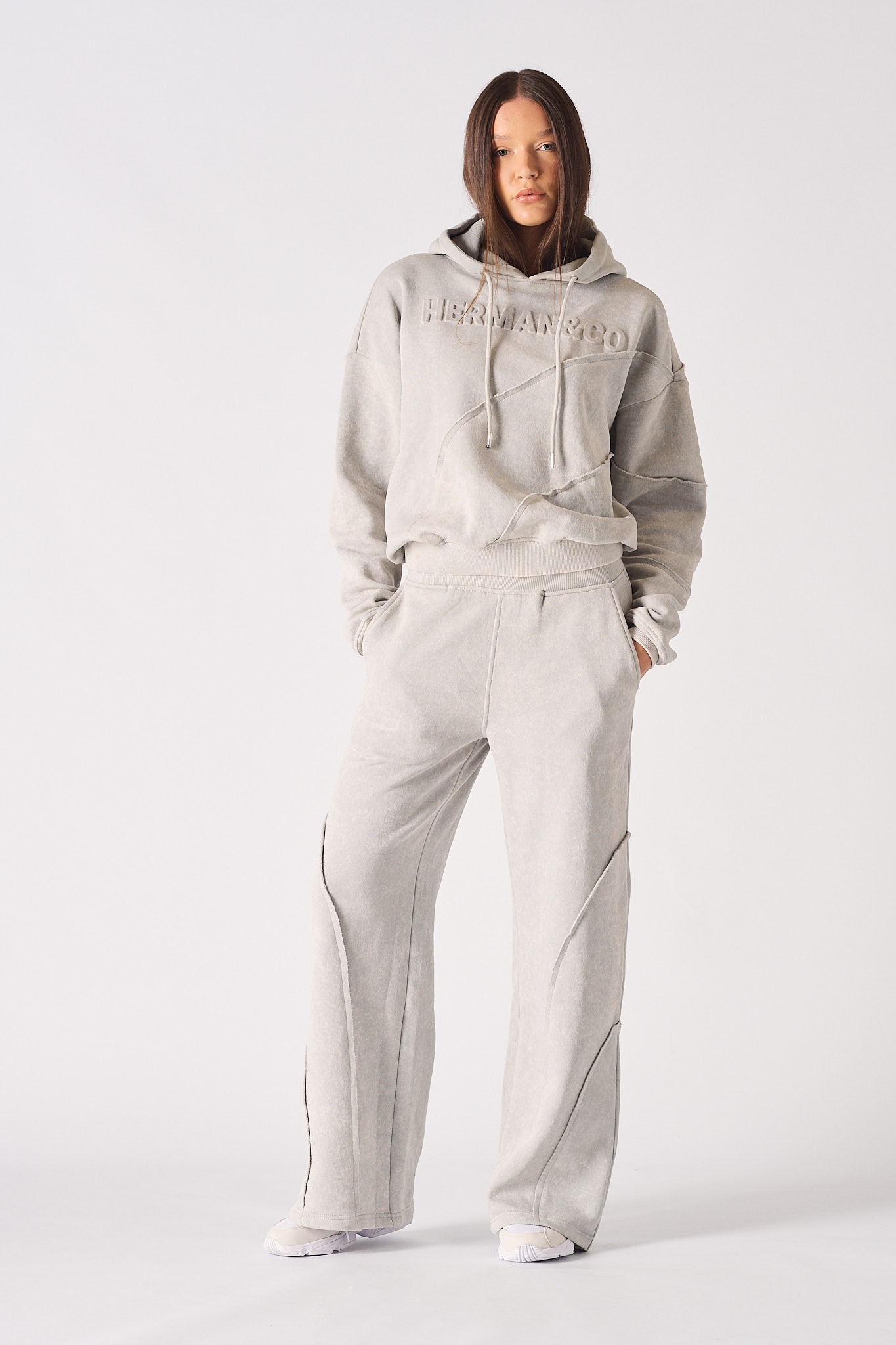 A model wearing the grey joggers with seam detail and a matching hoodie.