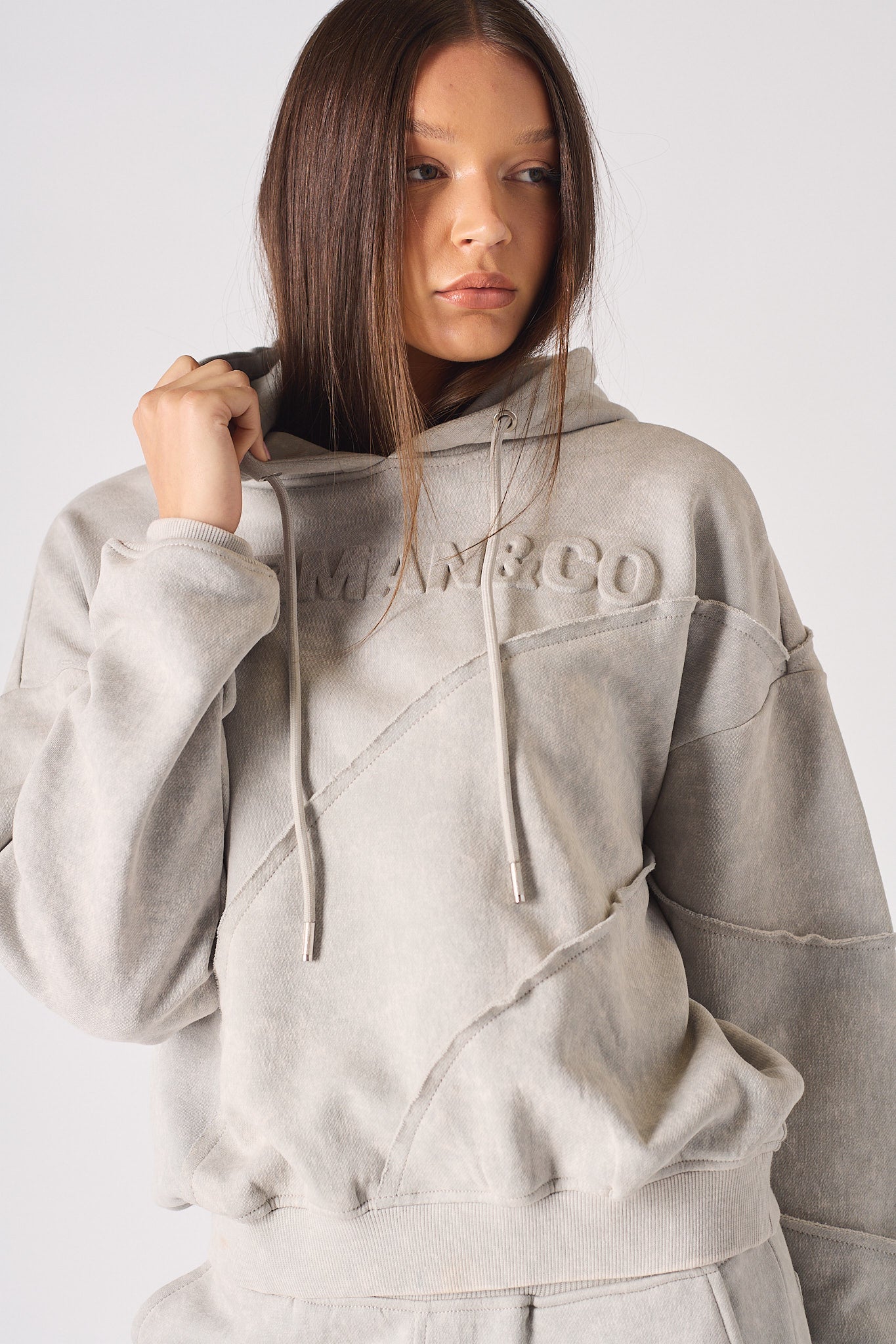 Full length side angle view of model wearing womens oversized grey hoodie and joggers