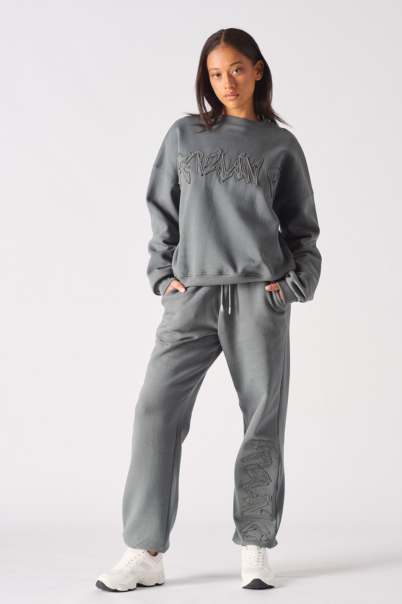 Full length side angle view of model wearing womens oversized grey sweatshirt and joggers