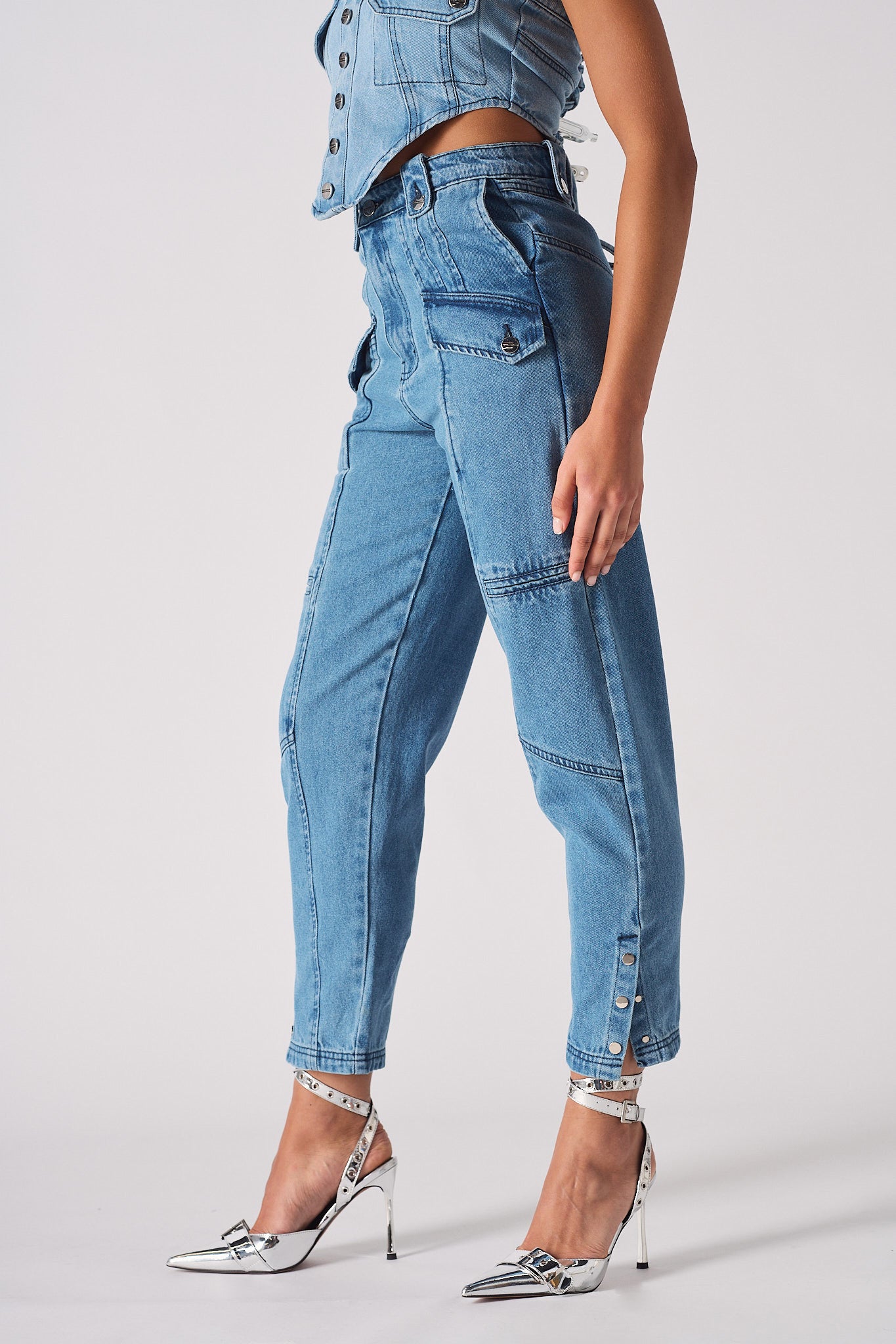 Side profile of a model wearing the women's mid-wash cargo denim jeans.