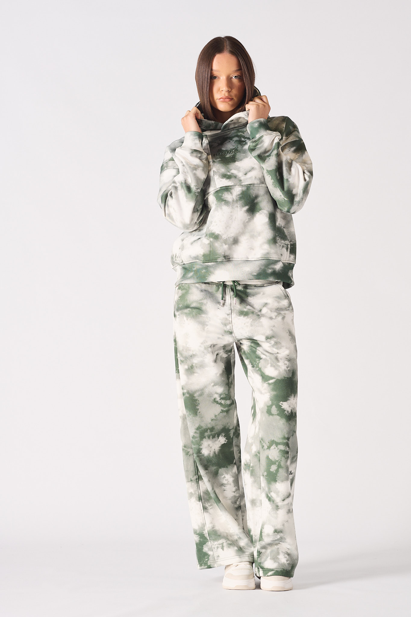 Front view of model wearing womens tie dye dark green hoodie with matching trousers