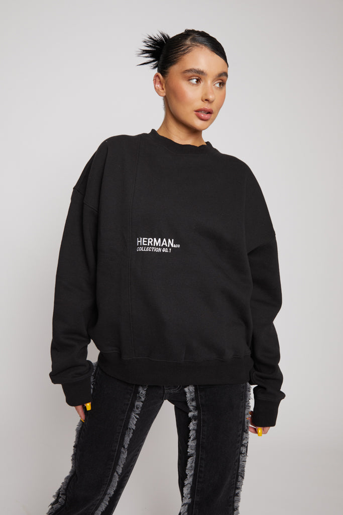 Mid shot of model wearing a stylish black crewneck sweatshirt with white logo detail