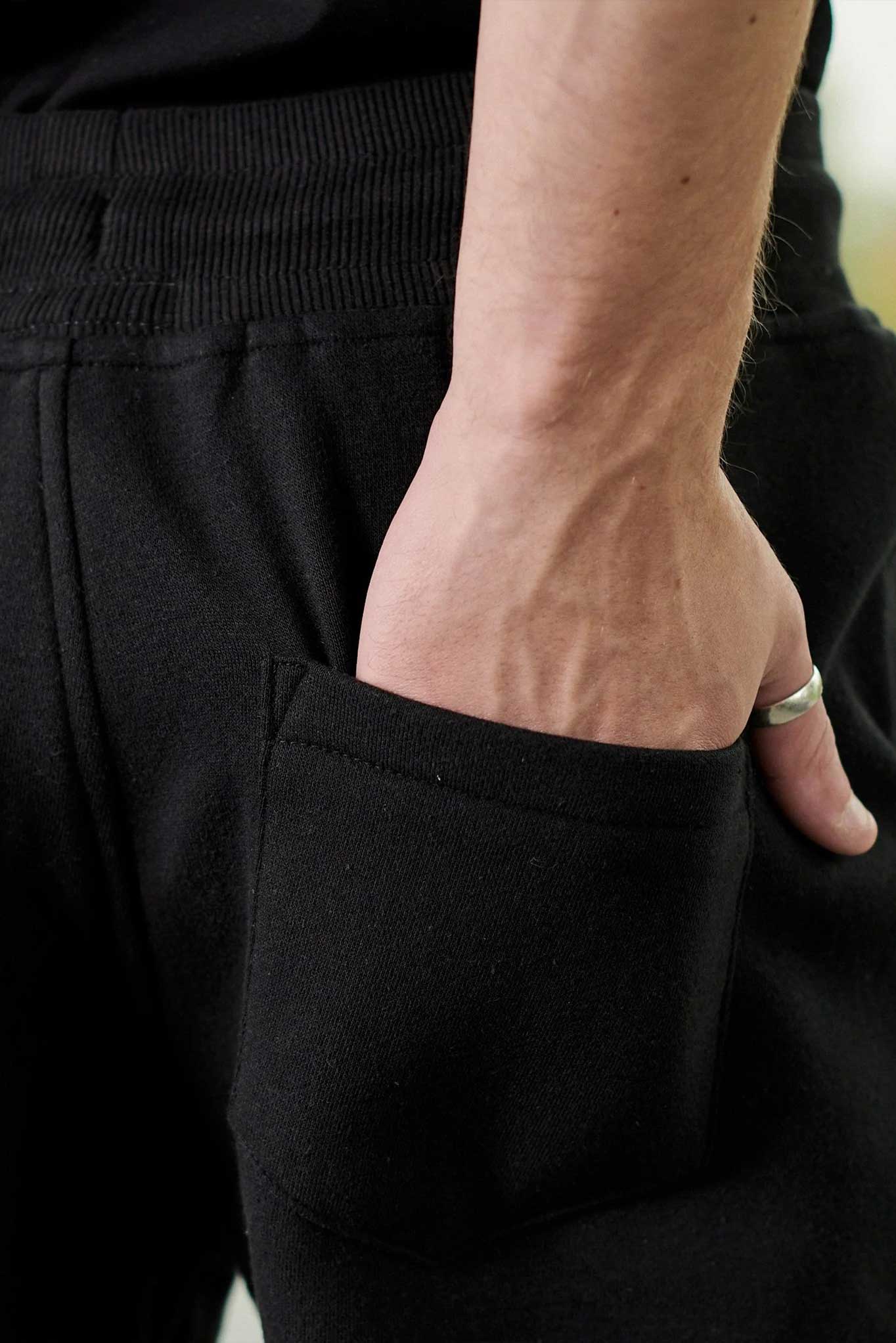 Detailed view of the side pocket on the men's black tapered joggers