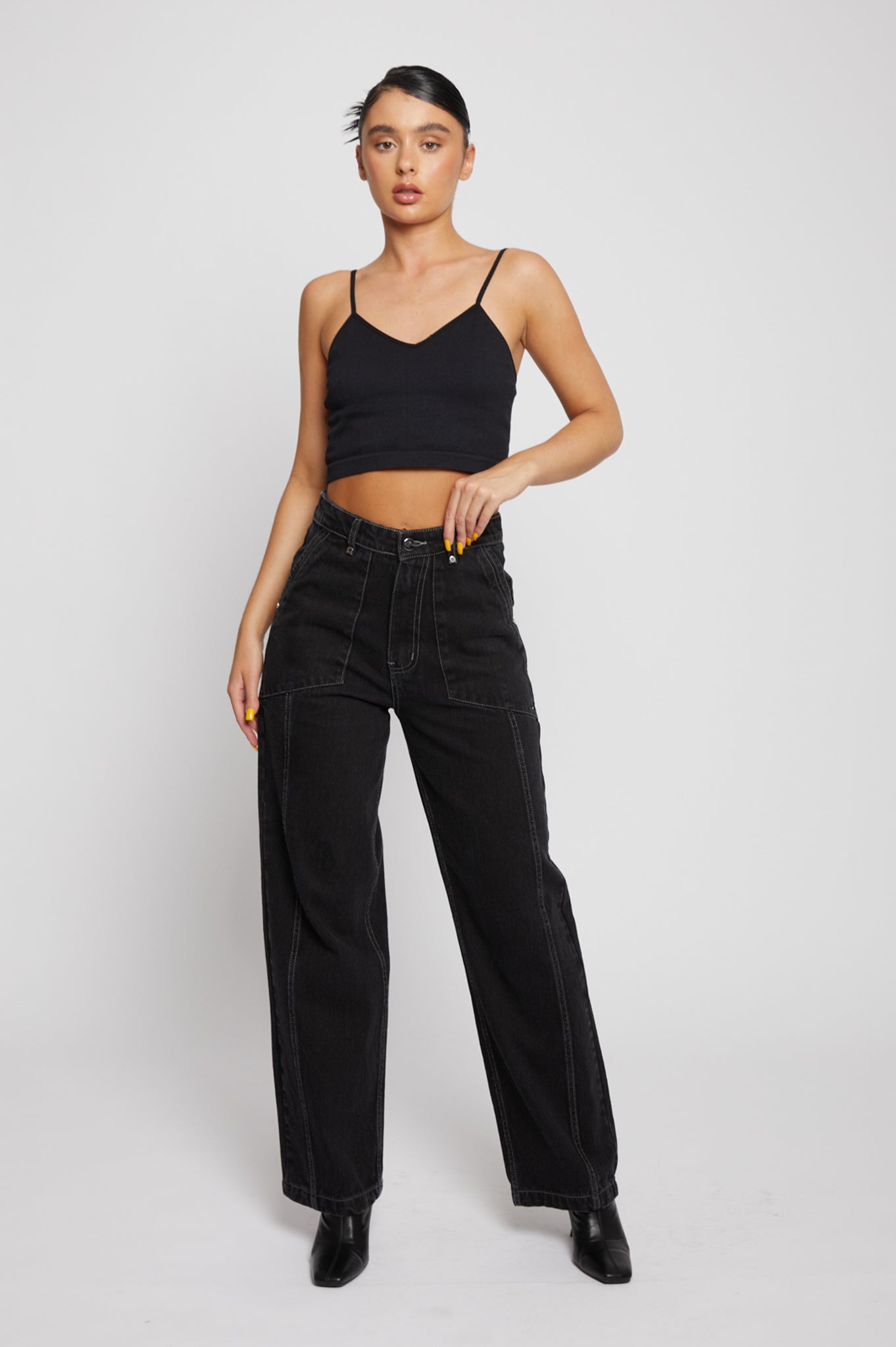 Full front view of a model styled in the black wash straight leg jeans.