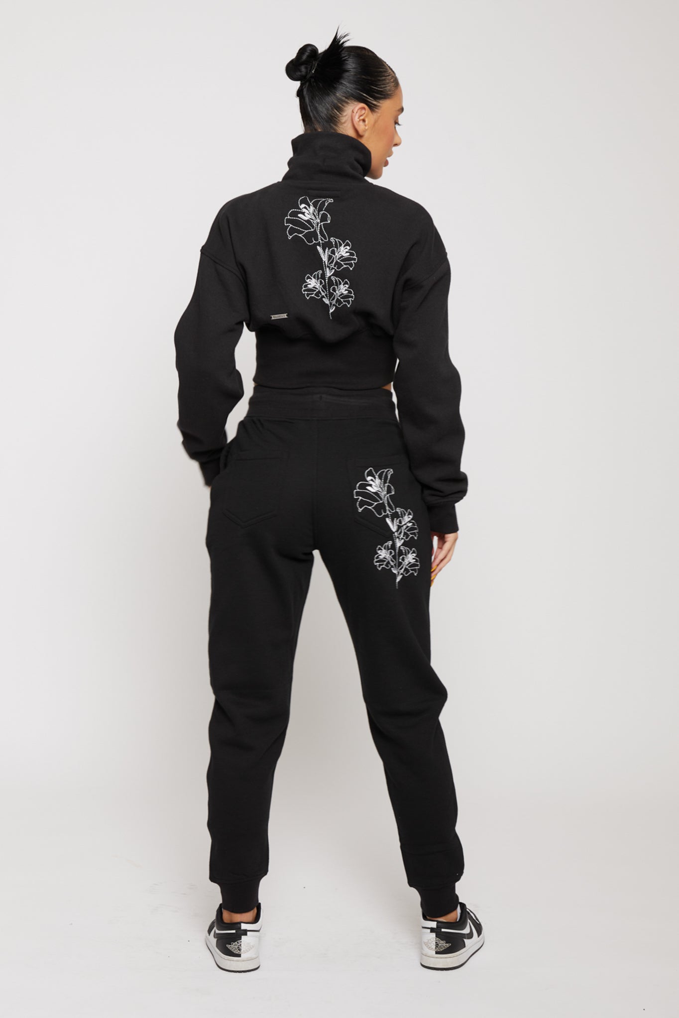 Rear view of womens black zip neck sweatshirt showing floral embroidery on the back