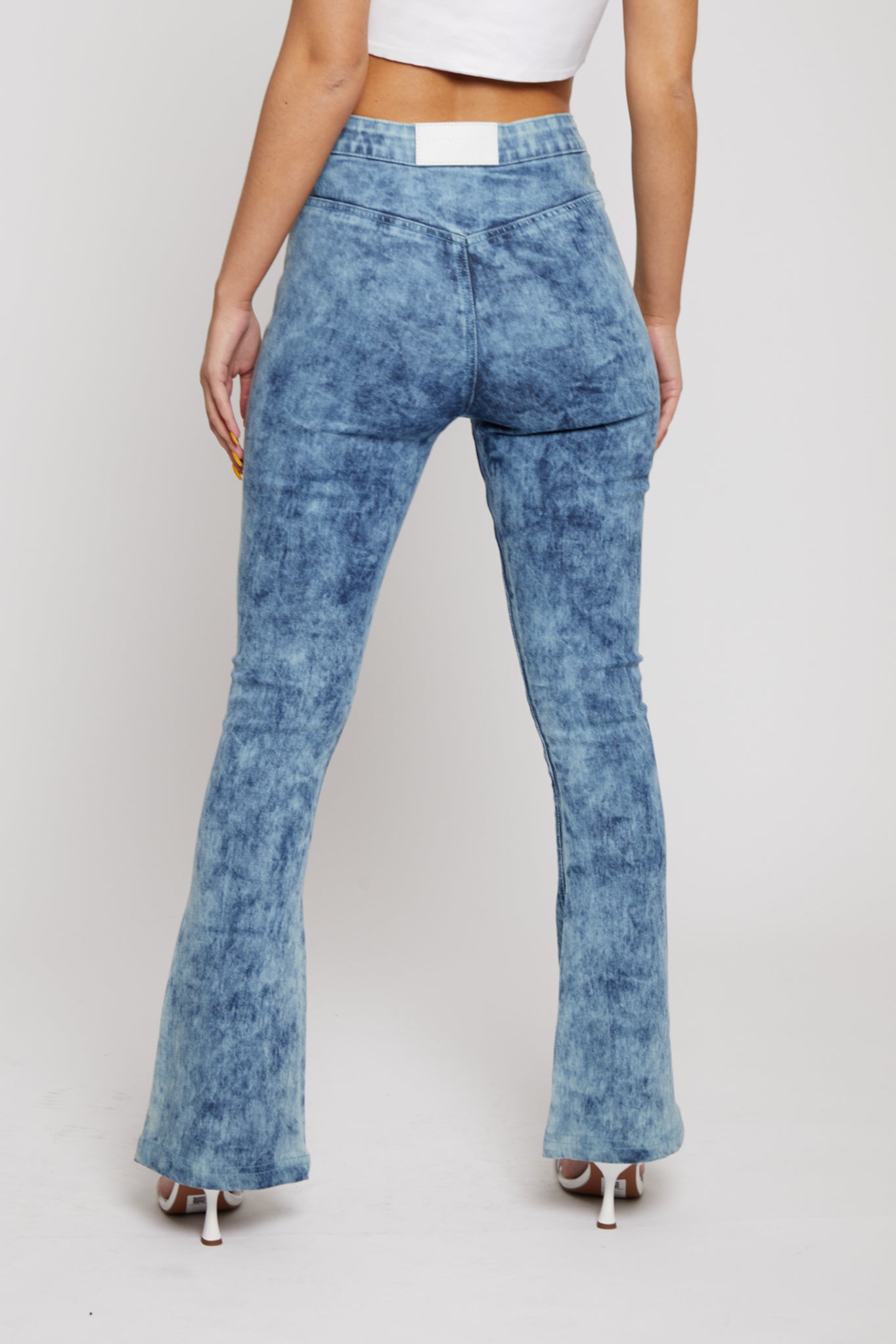 Close up back view of blue acid wash jeans showing pocketless design