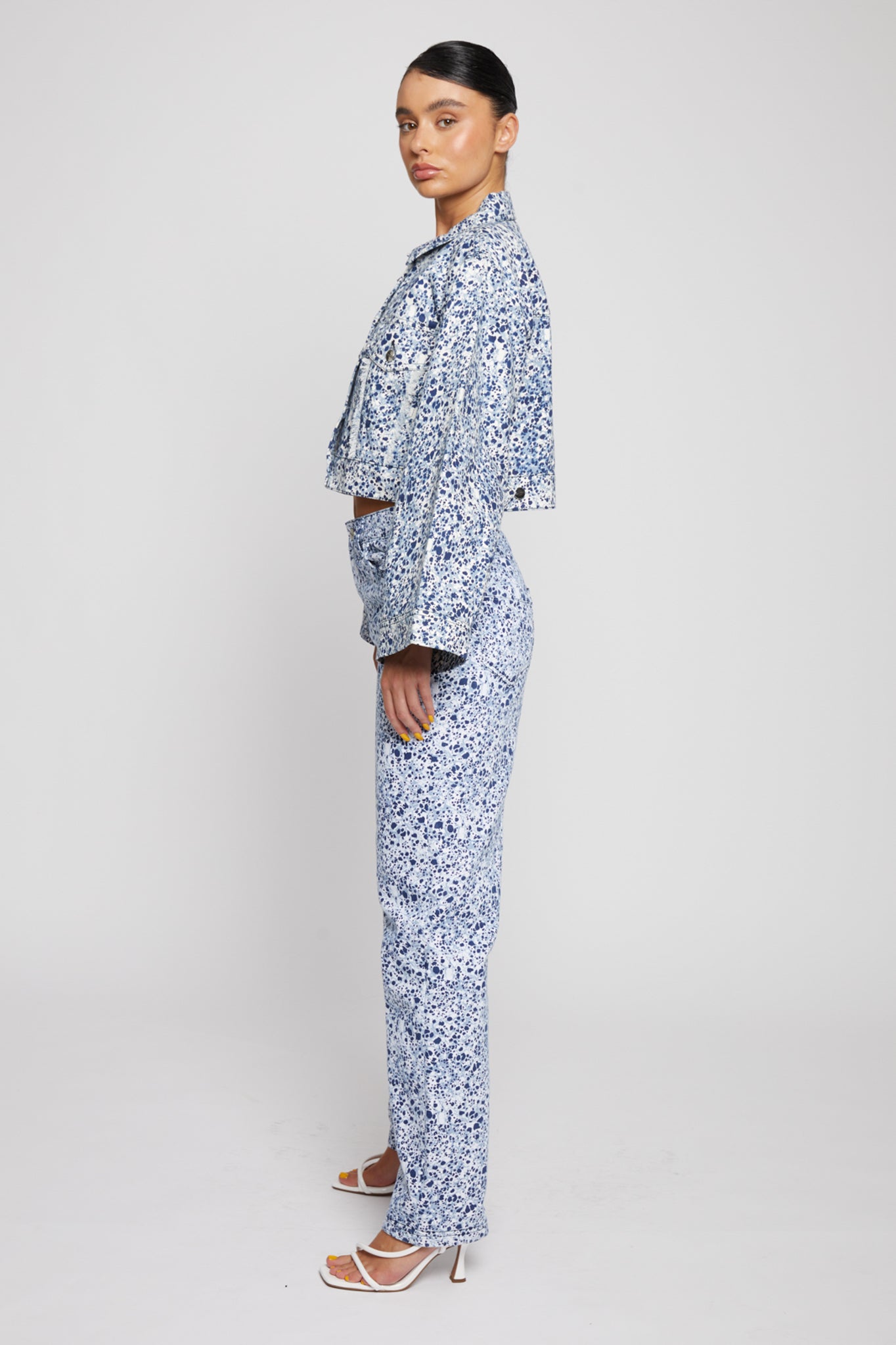 Side profile of the cropped marble denim jacket showing the flared sleeves.