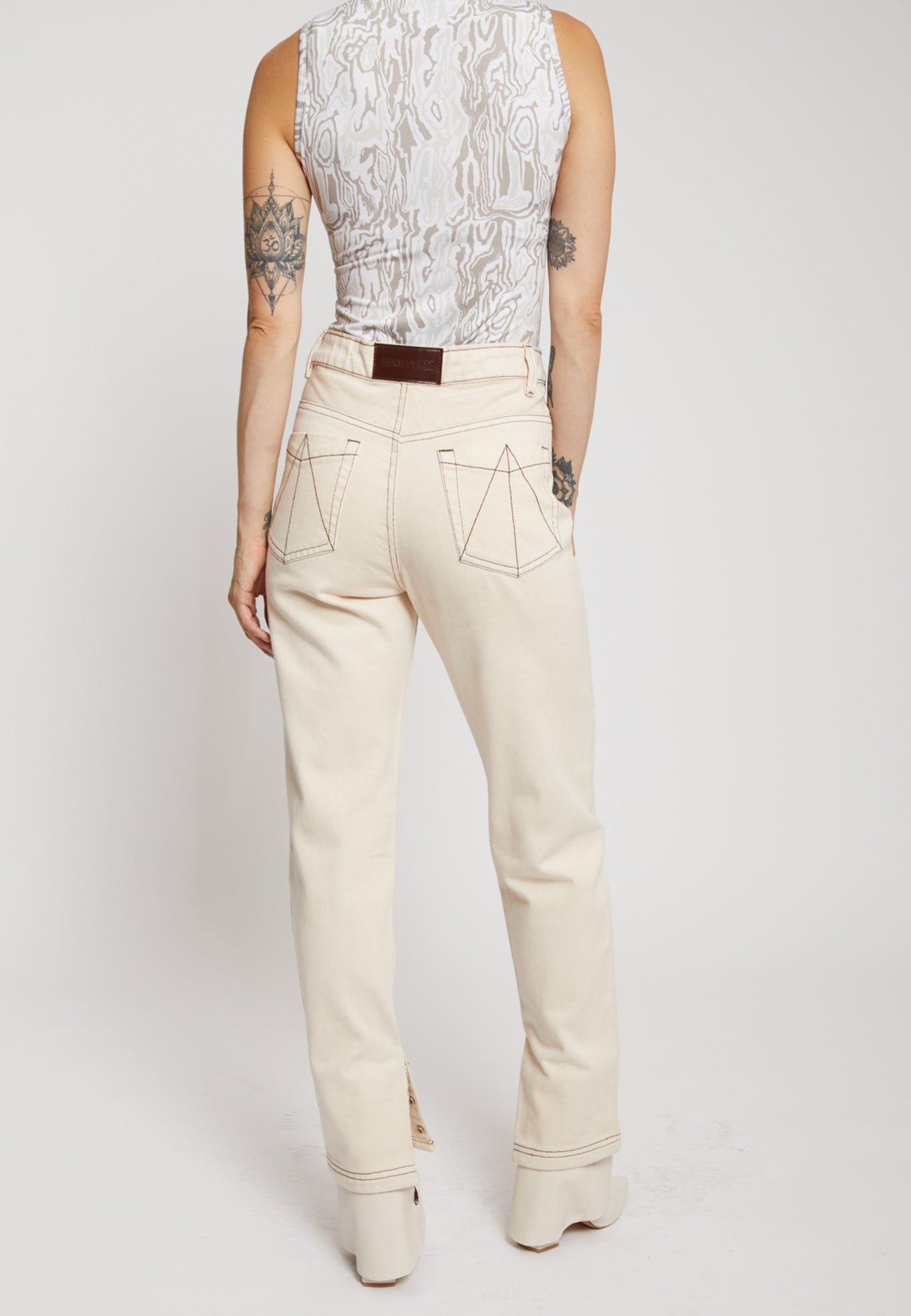 Back view of the ecru denim jeans showing the unique pocket stitching.