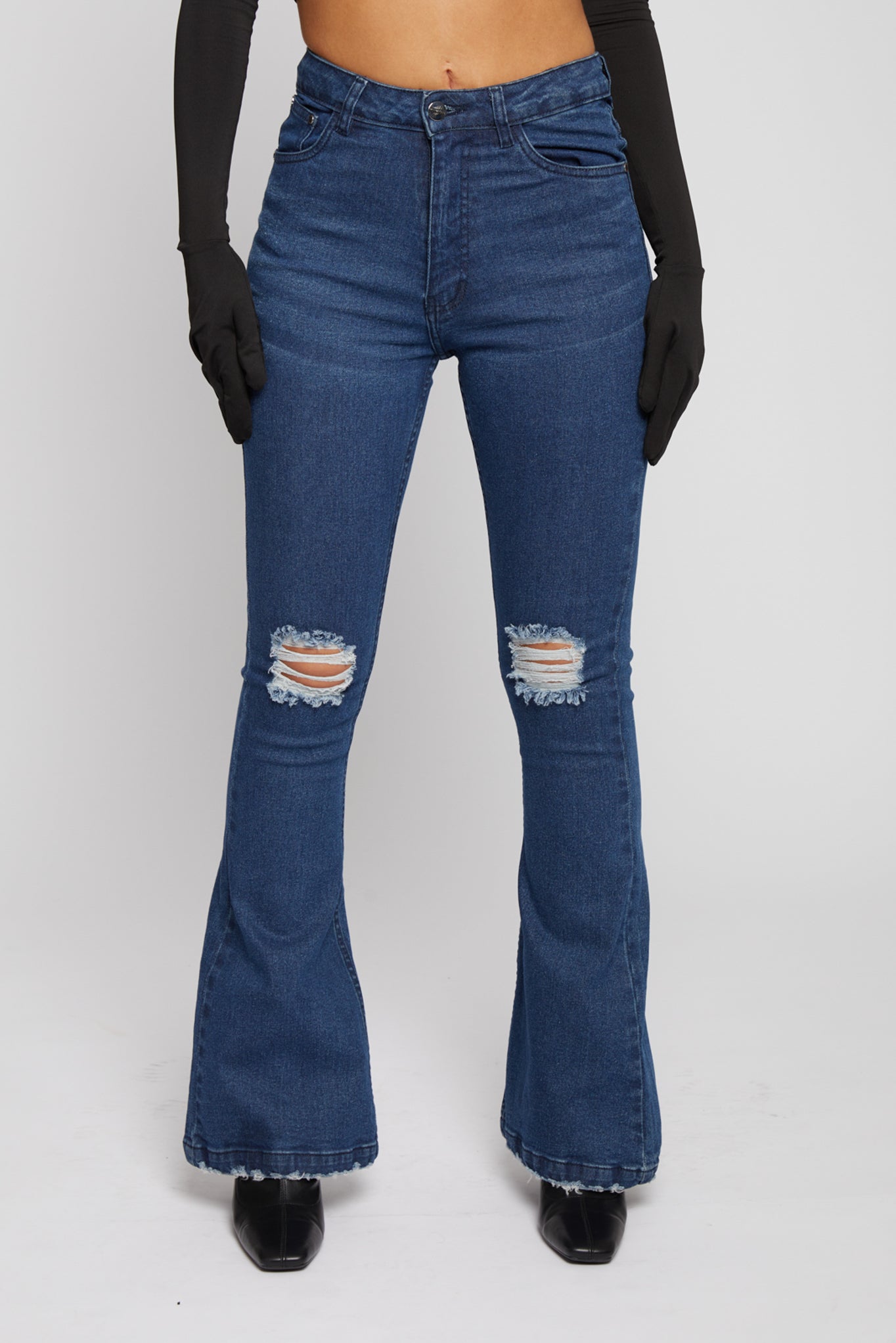 Close-up of the women's flare jeans showing the distressed knee details.