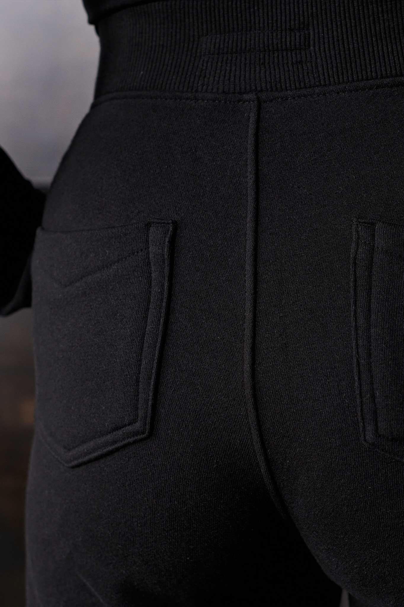 Close-up of the back pocket detail on the fleece section of the joggers