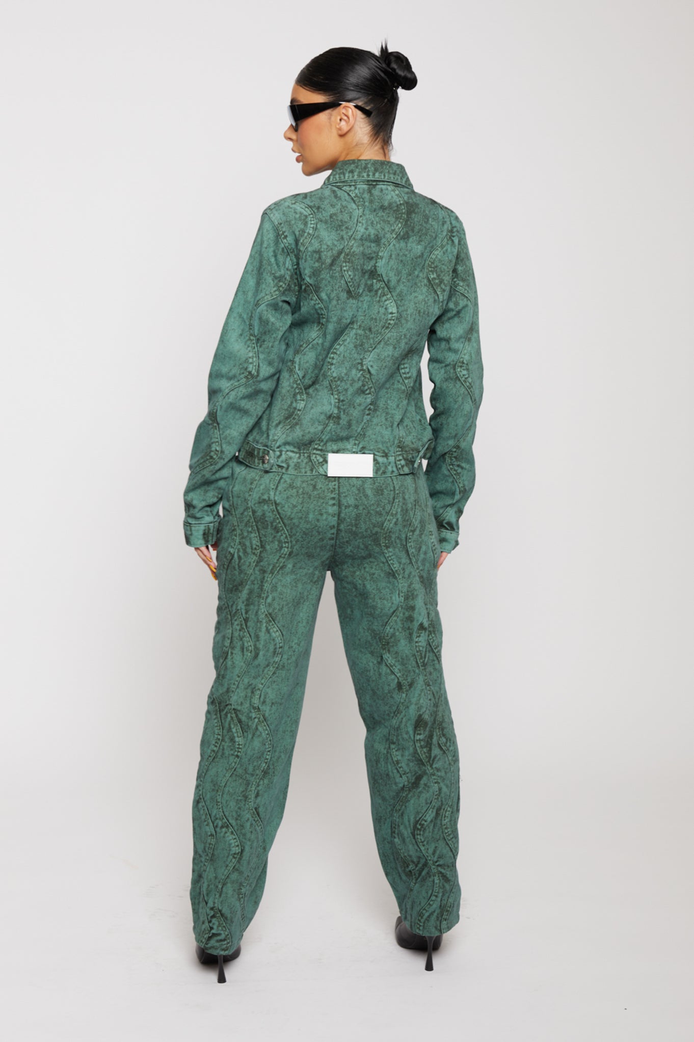 Back view of a model in the green acid washed jeans and matching jacket.