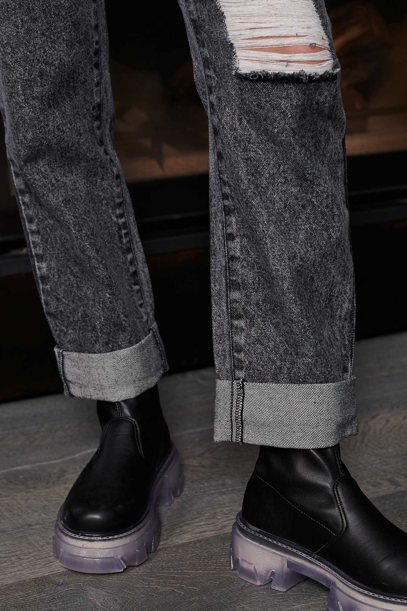 Close-up of the stylish turn-up hem on the grey acid wash jeans